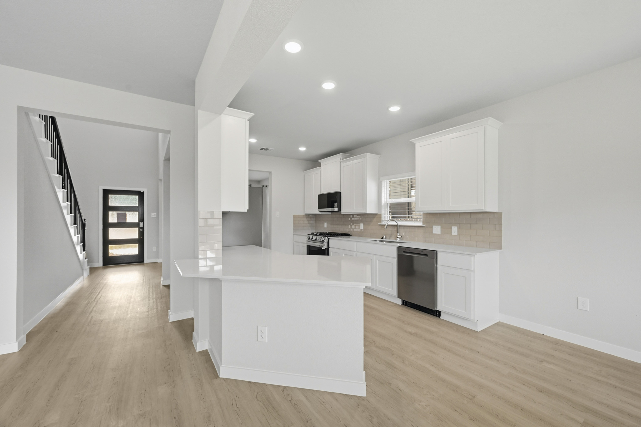 A kitchen with white cabinets.