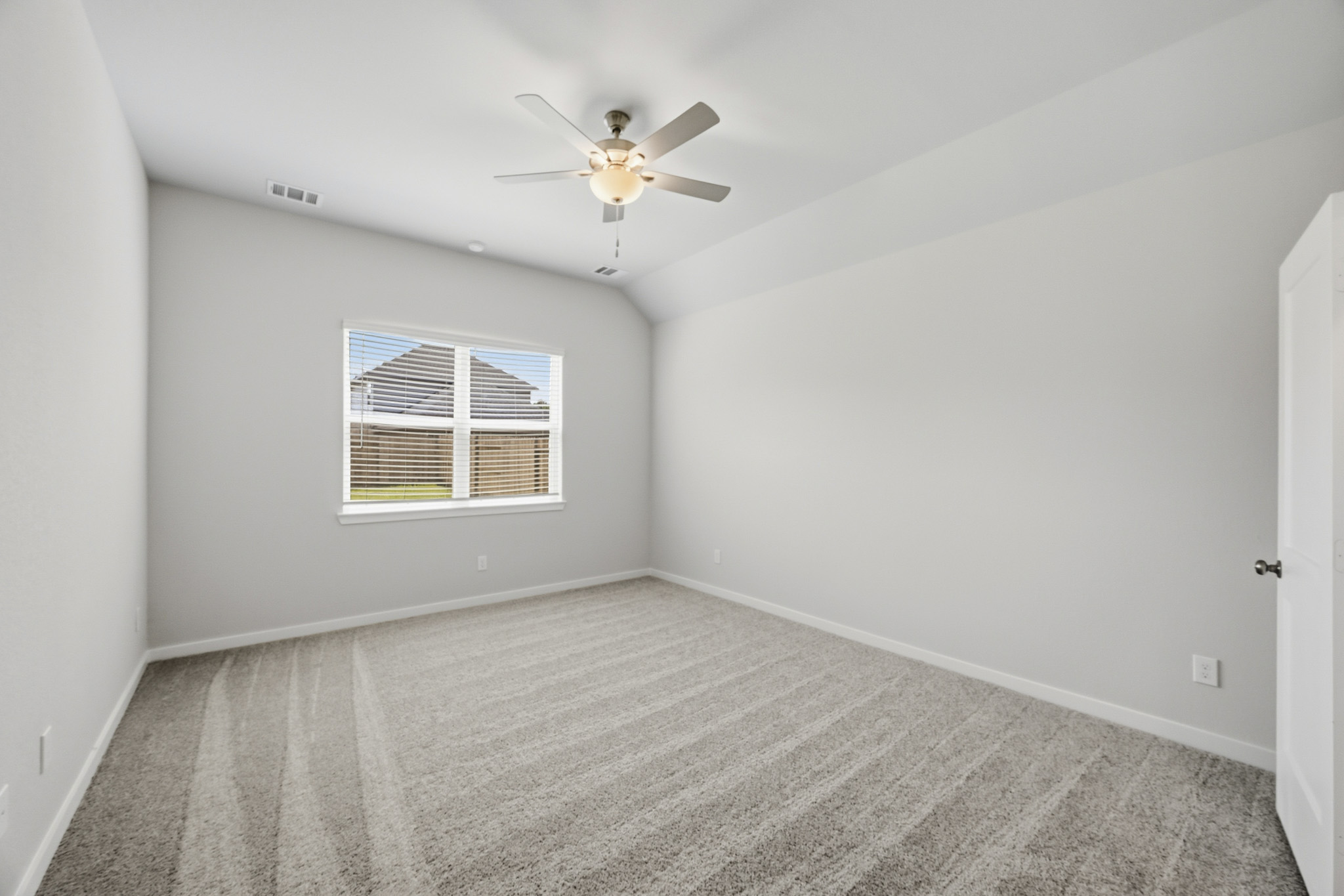 A room with a ceiling fan and a window.