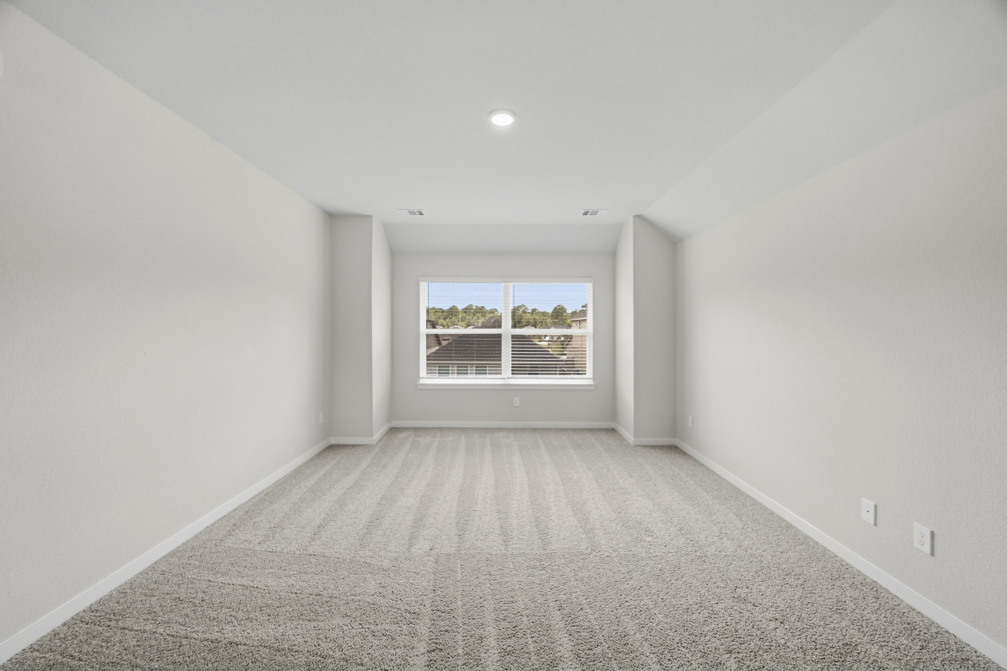 A room with a window and a carpet.