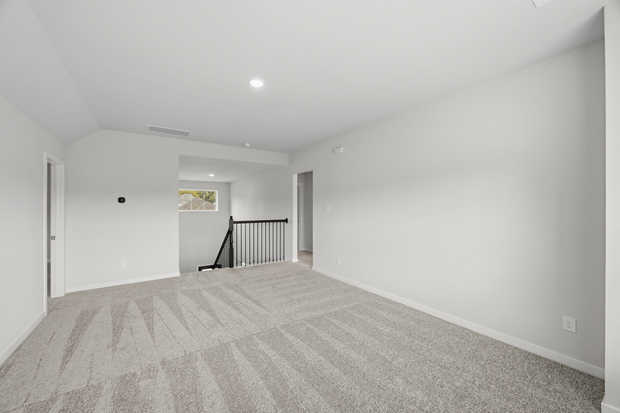 A room with a carpet and a railing.