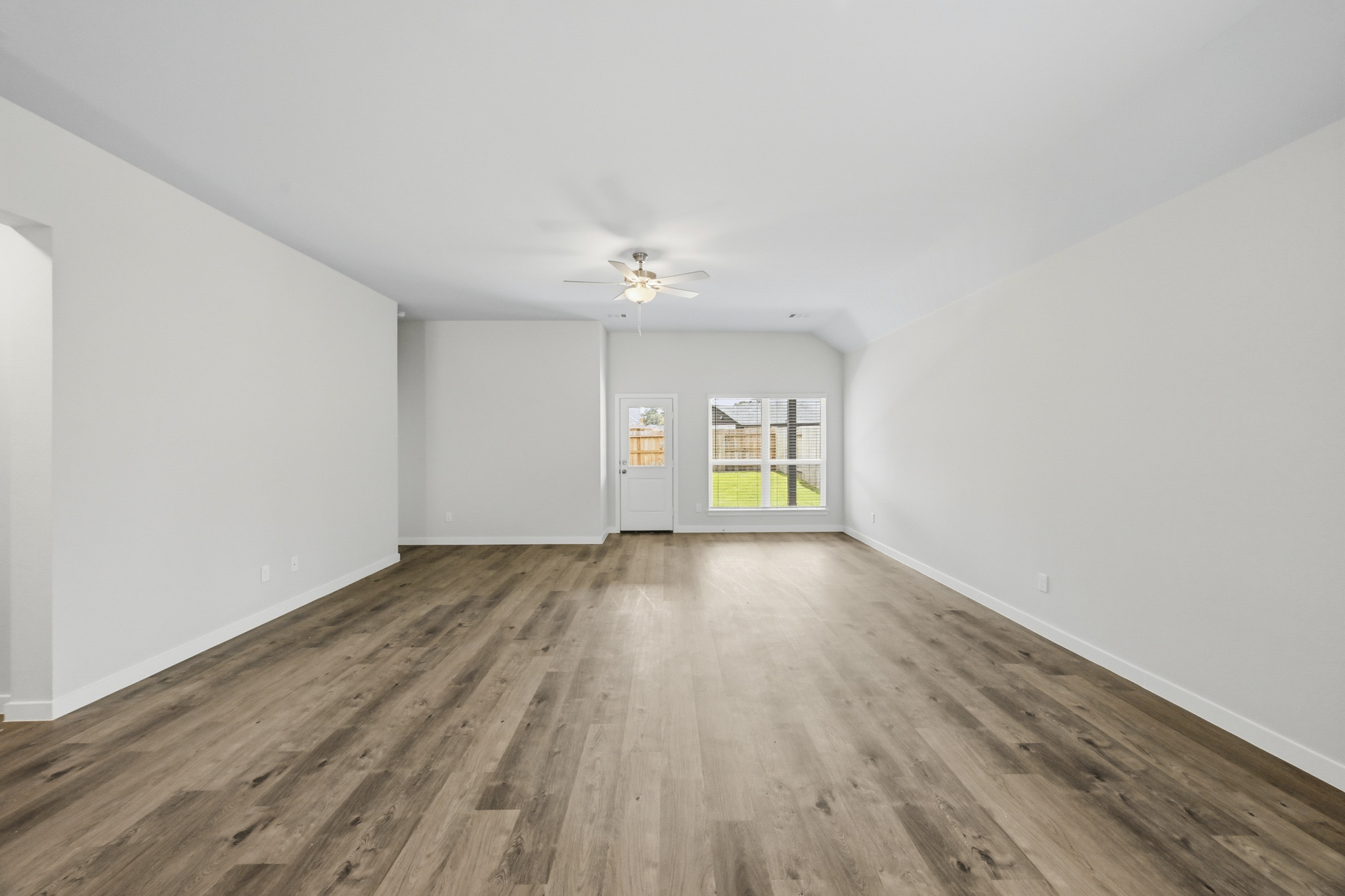 A room with a wood floor and a ceiling fan.