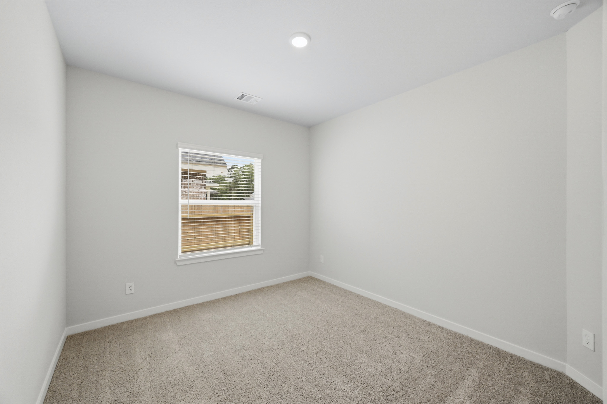 A room with a window and a carpet.