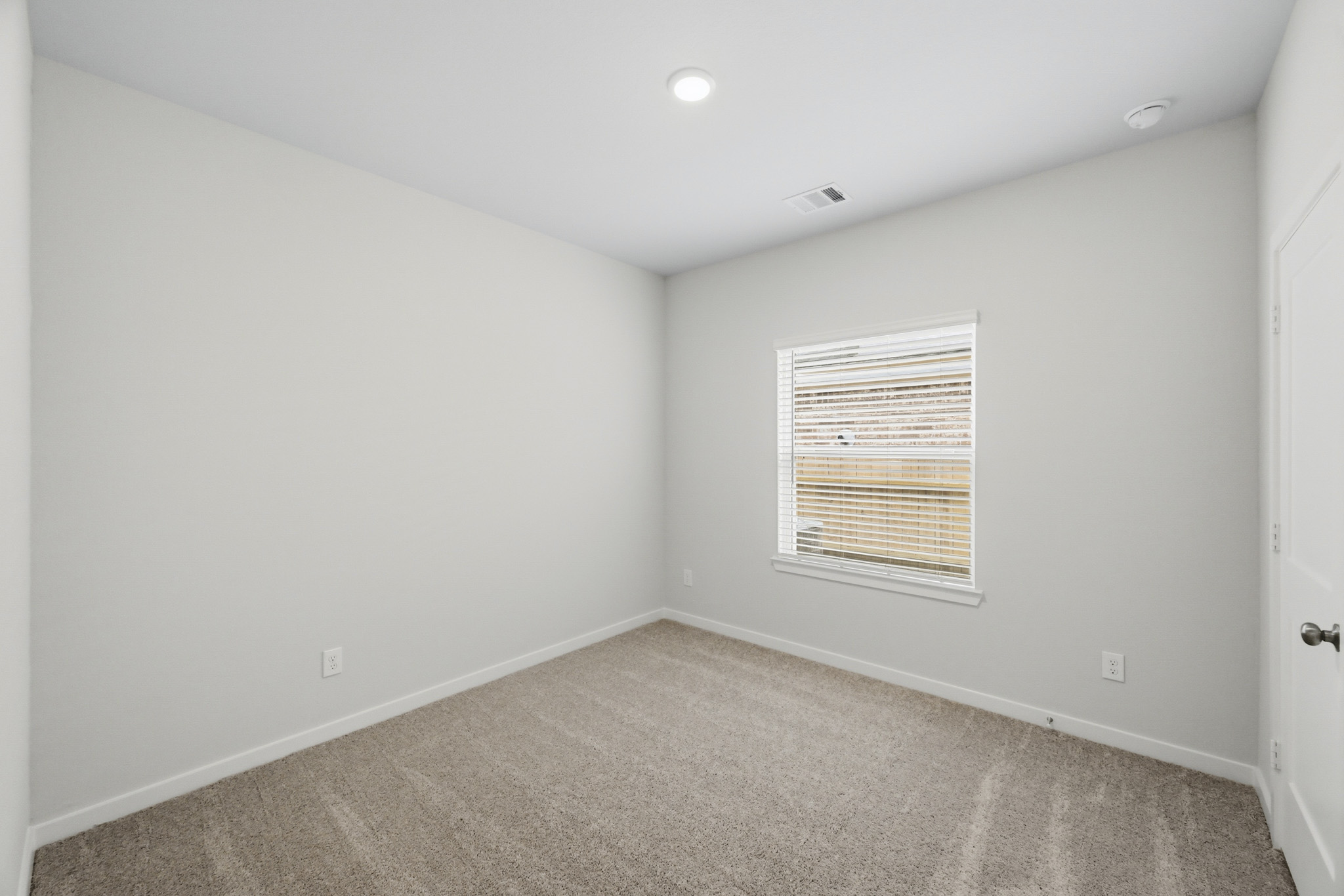 A room with a carpet and a window.