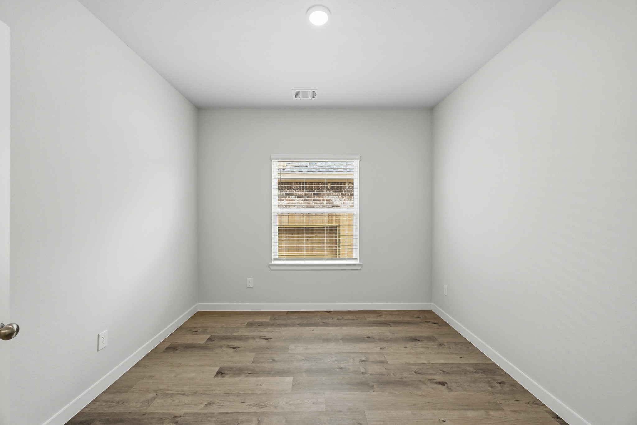 A room with a wood floor and a window.