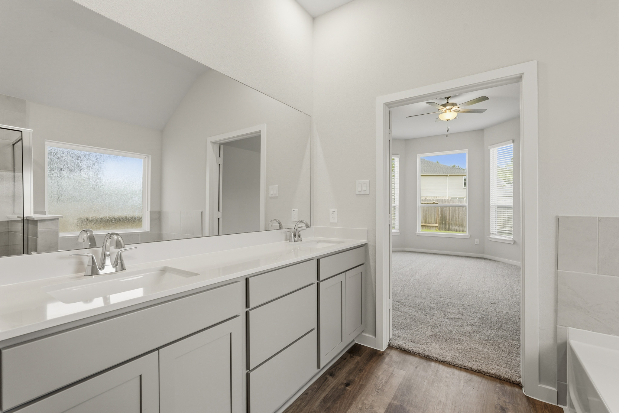 A bathroom with white cabinets.
