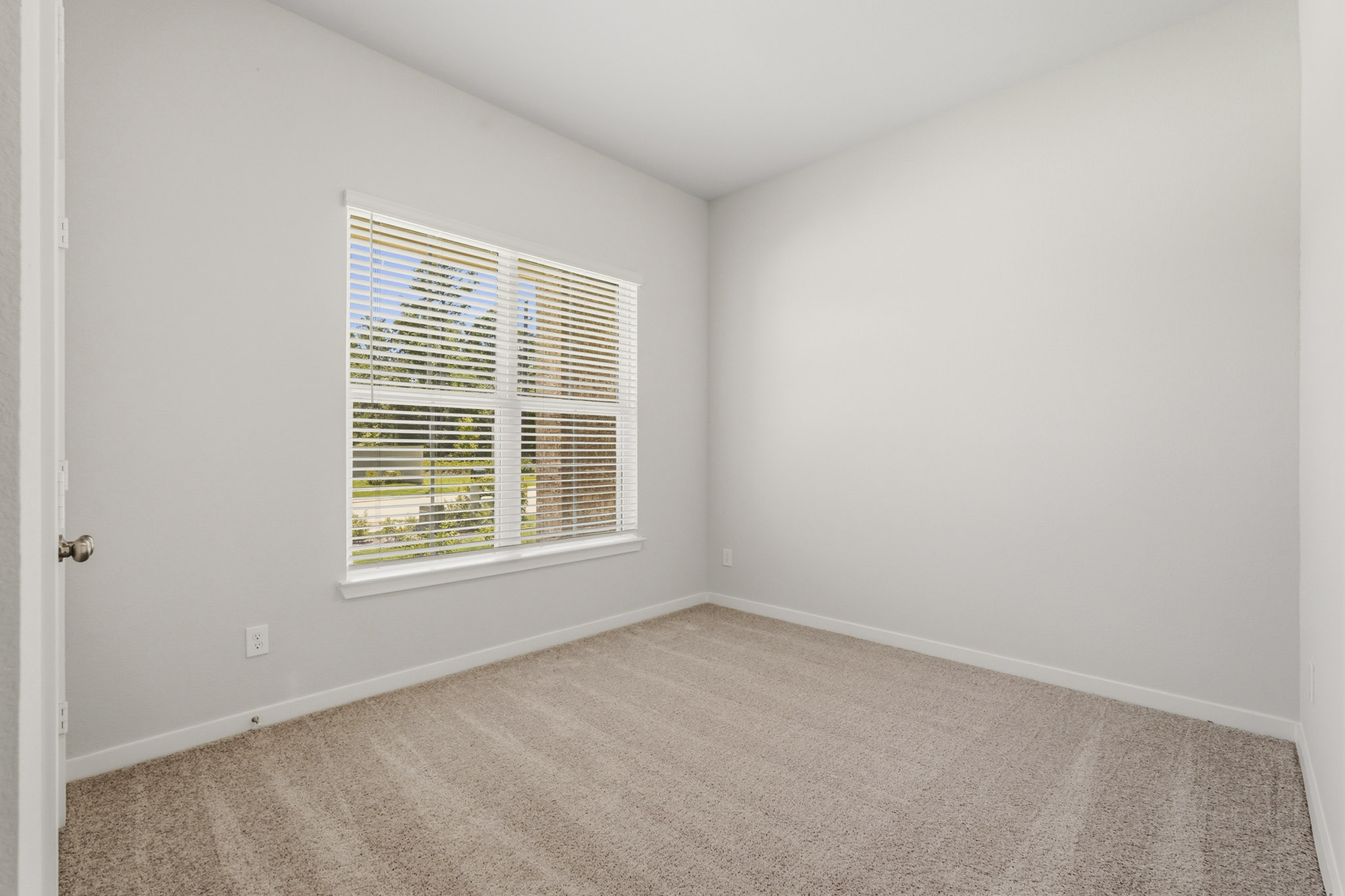 A room with a window and carpet.