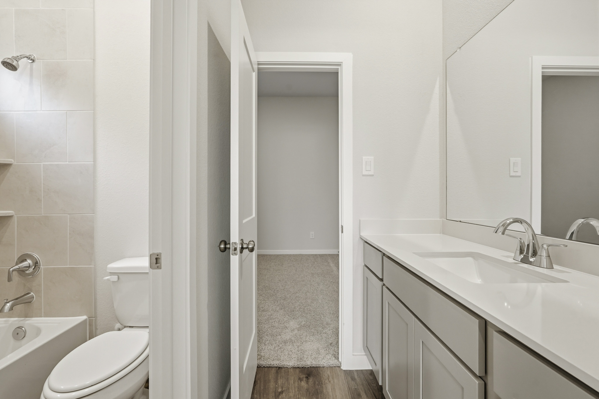 A bathroom with a sink toilet and mirror.