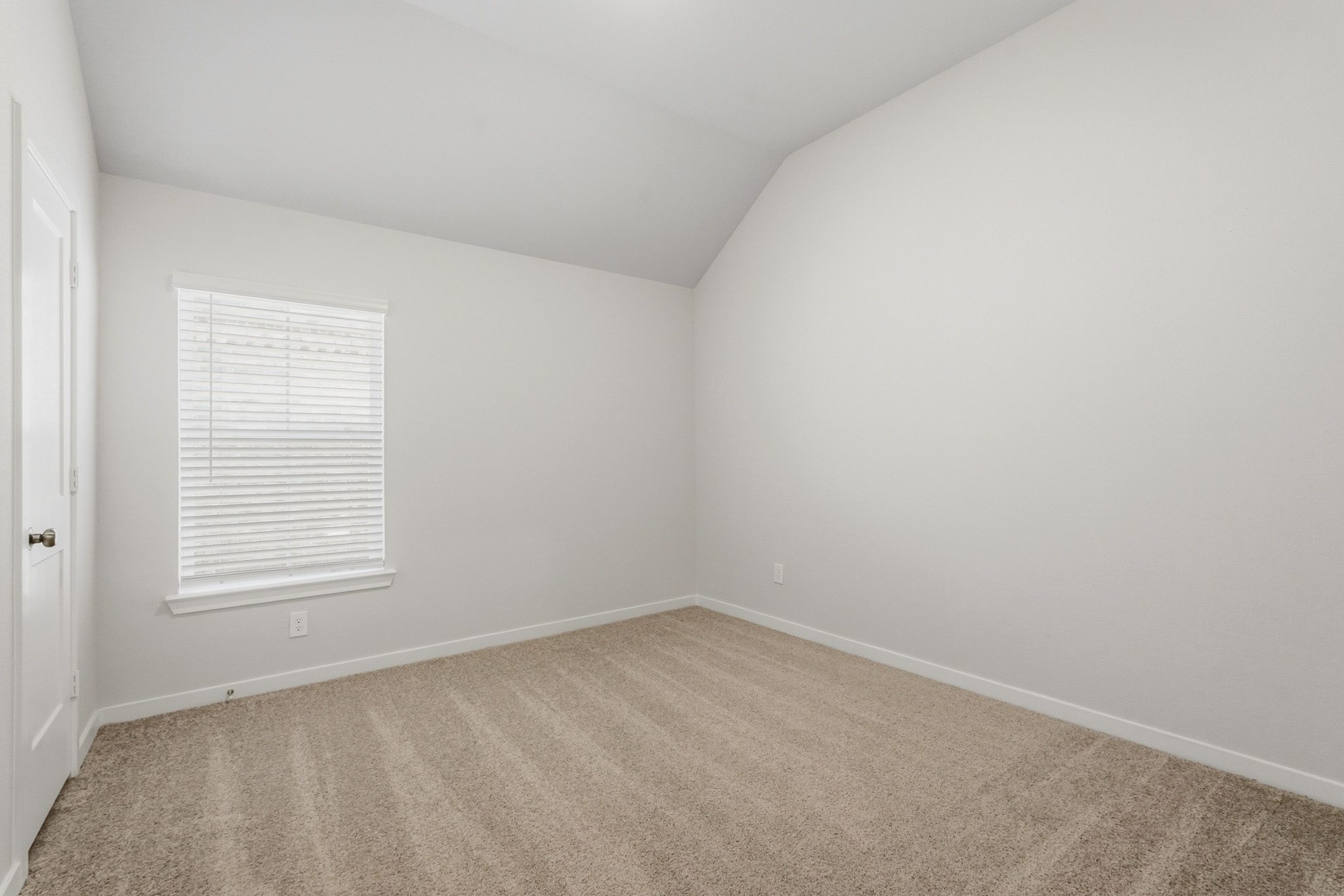 A room with a carpet and a window.