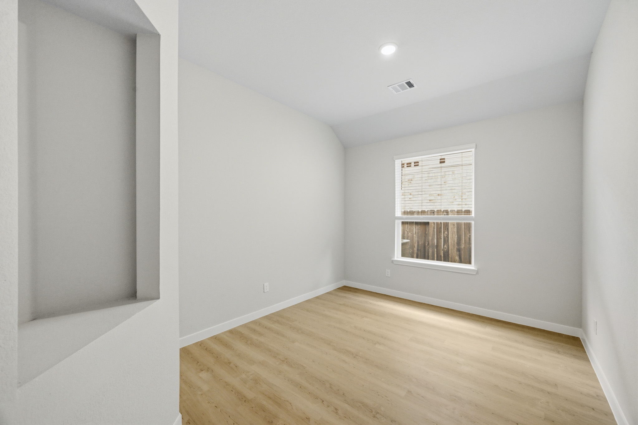 A room with a wood floor and white walls.