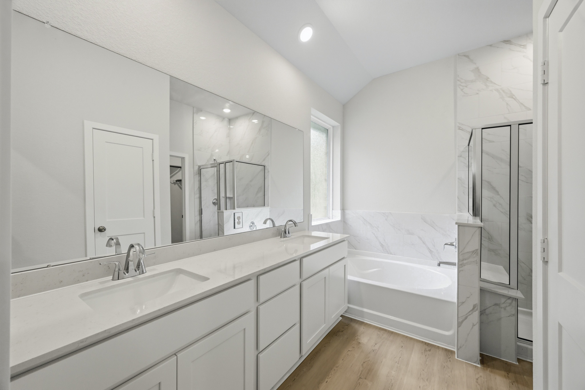 A bathroom with a tub sink and mirror.