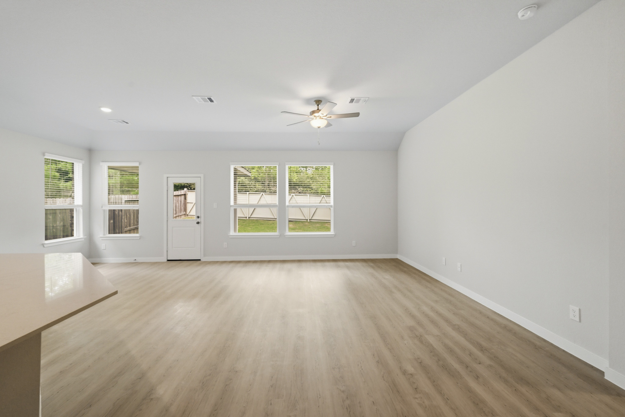 A room with a wood floor and a wood floor with a ceiling fan.