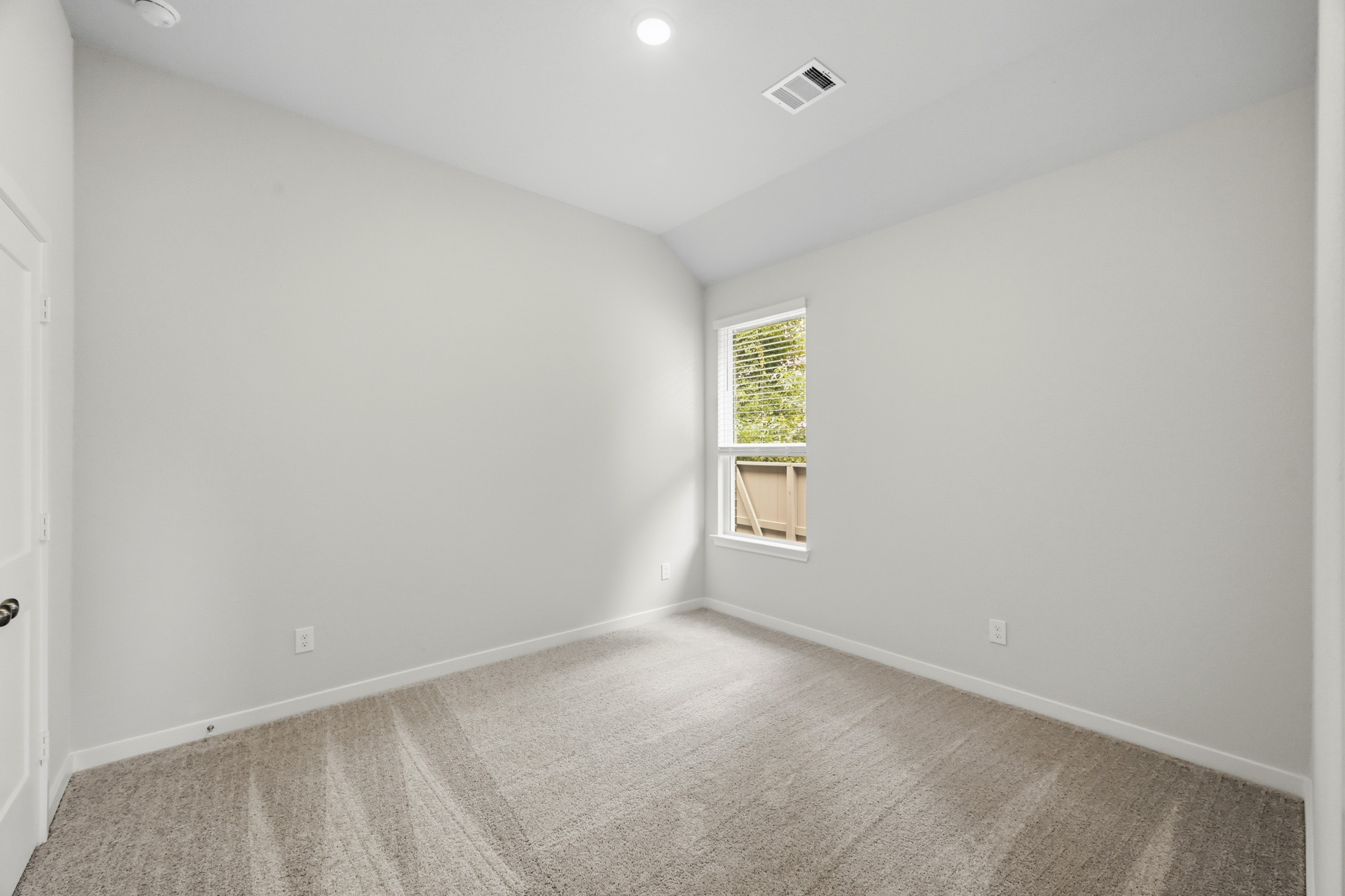 A room with a carpet and a window.