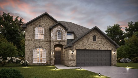 A stone house with a driveway.