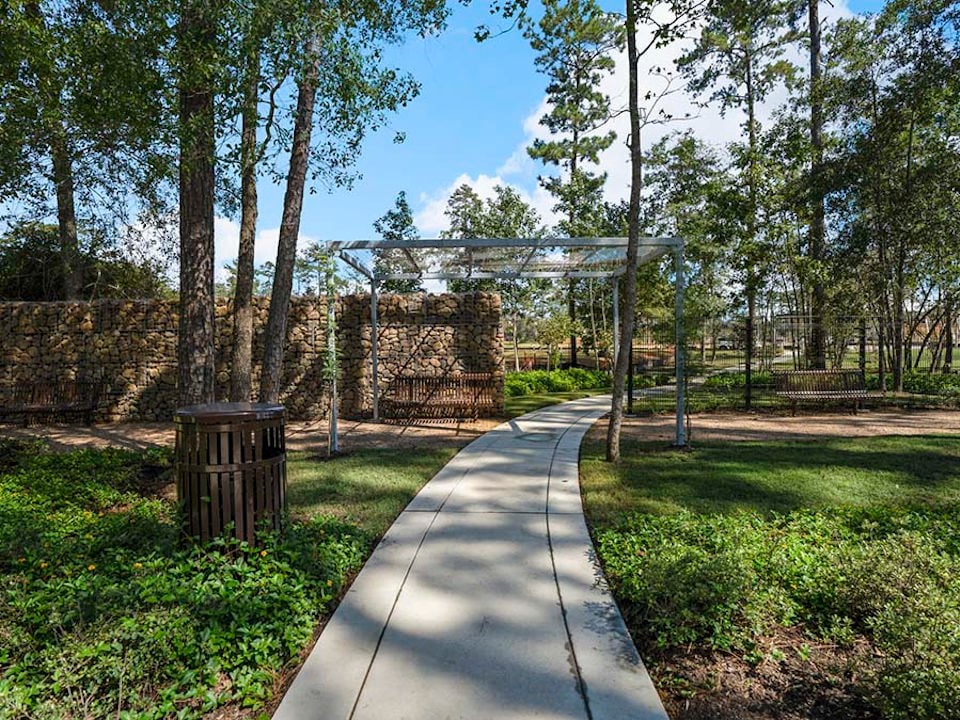 A path with a metal gate and trees on the side.