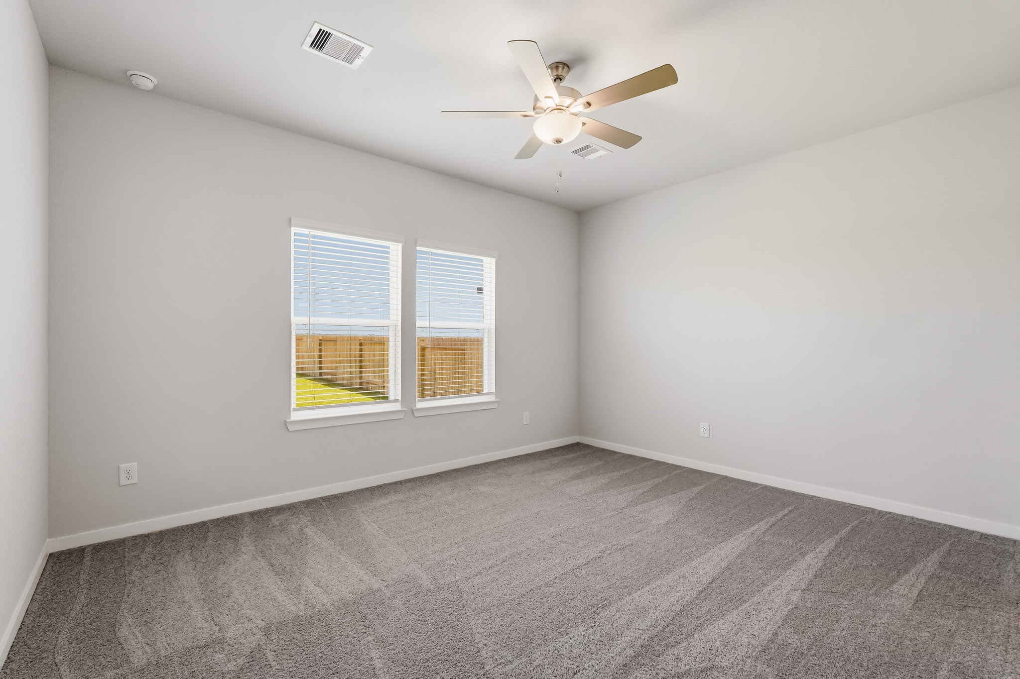 A room with a ceiling fan and a window.