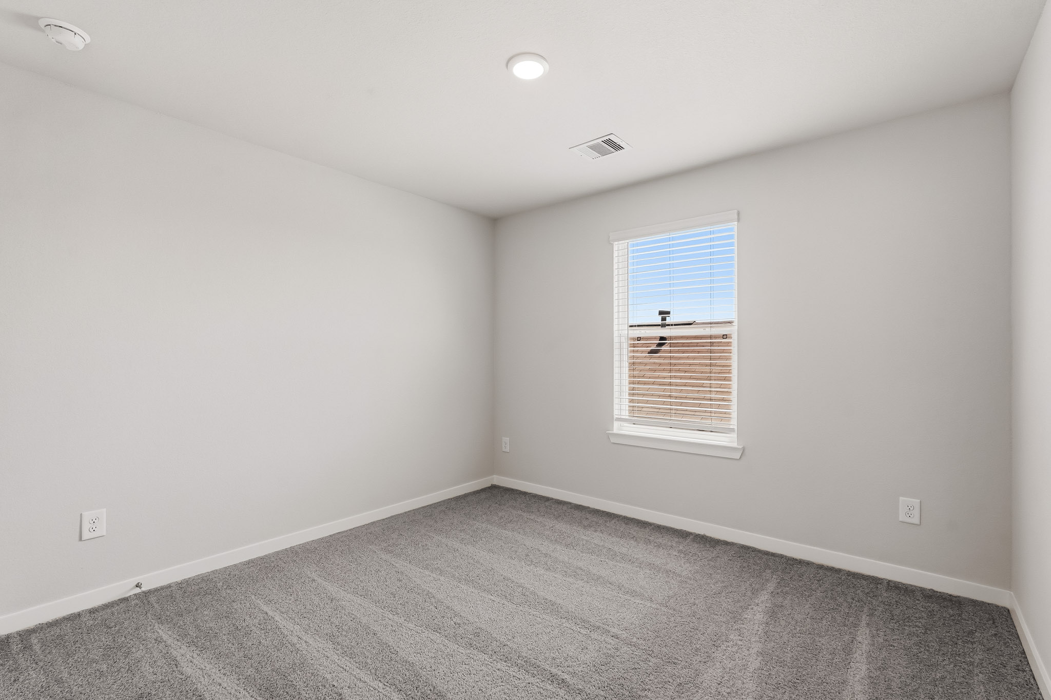 A room with a window and a carpet.