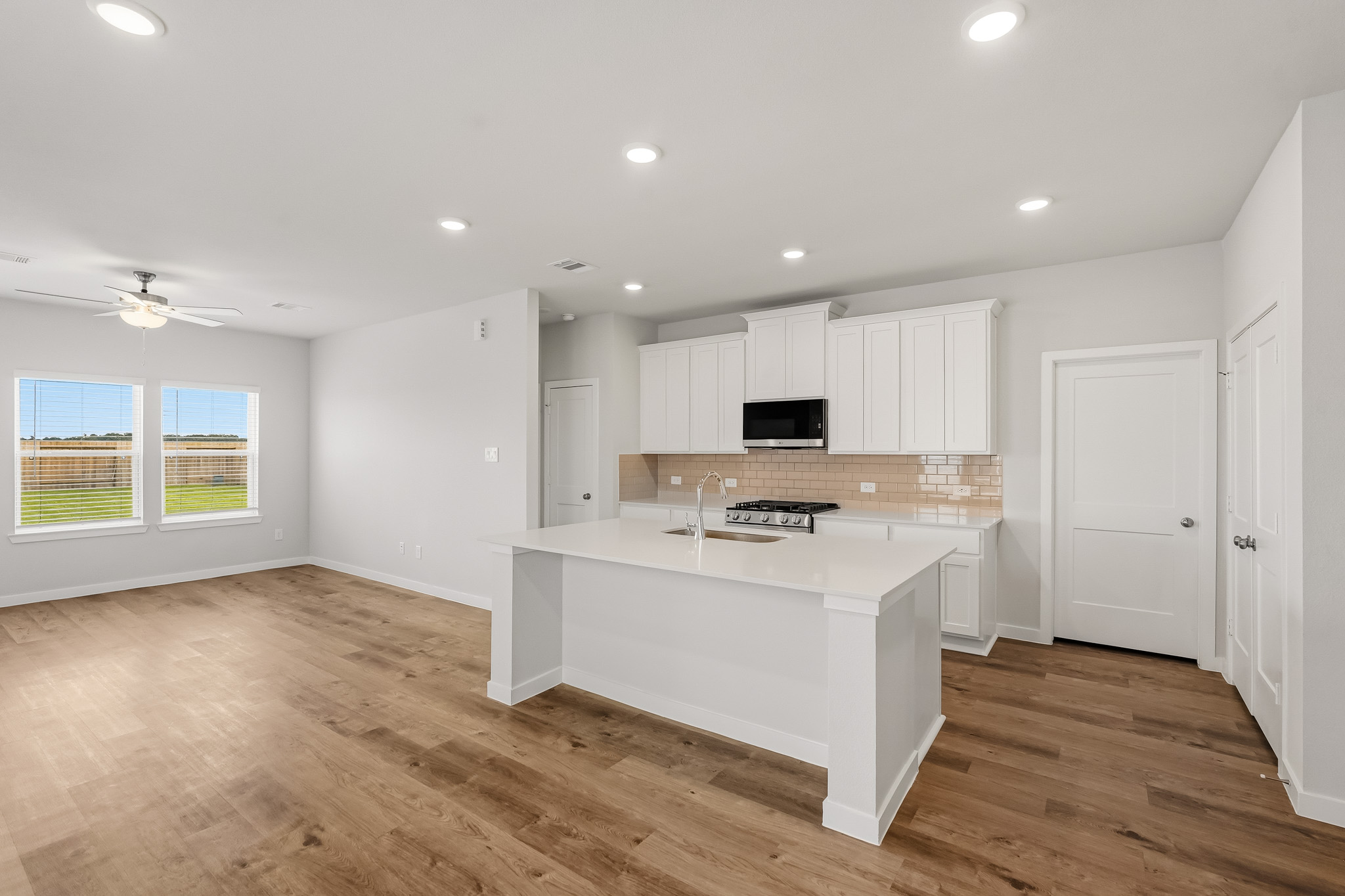 A kitchen with white cabinets.