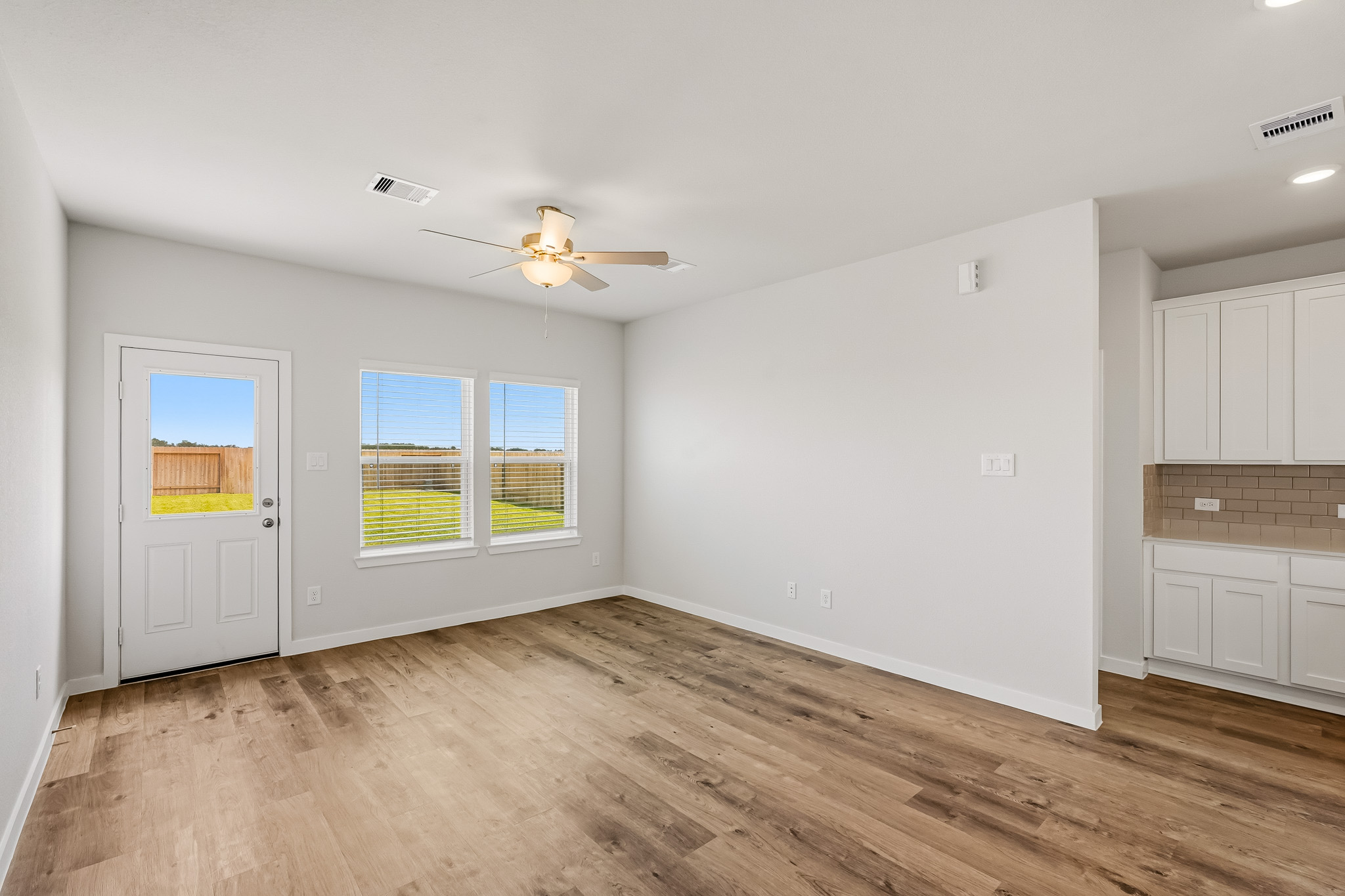 A room with a wood floor and a ceiling fan.