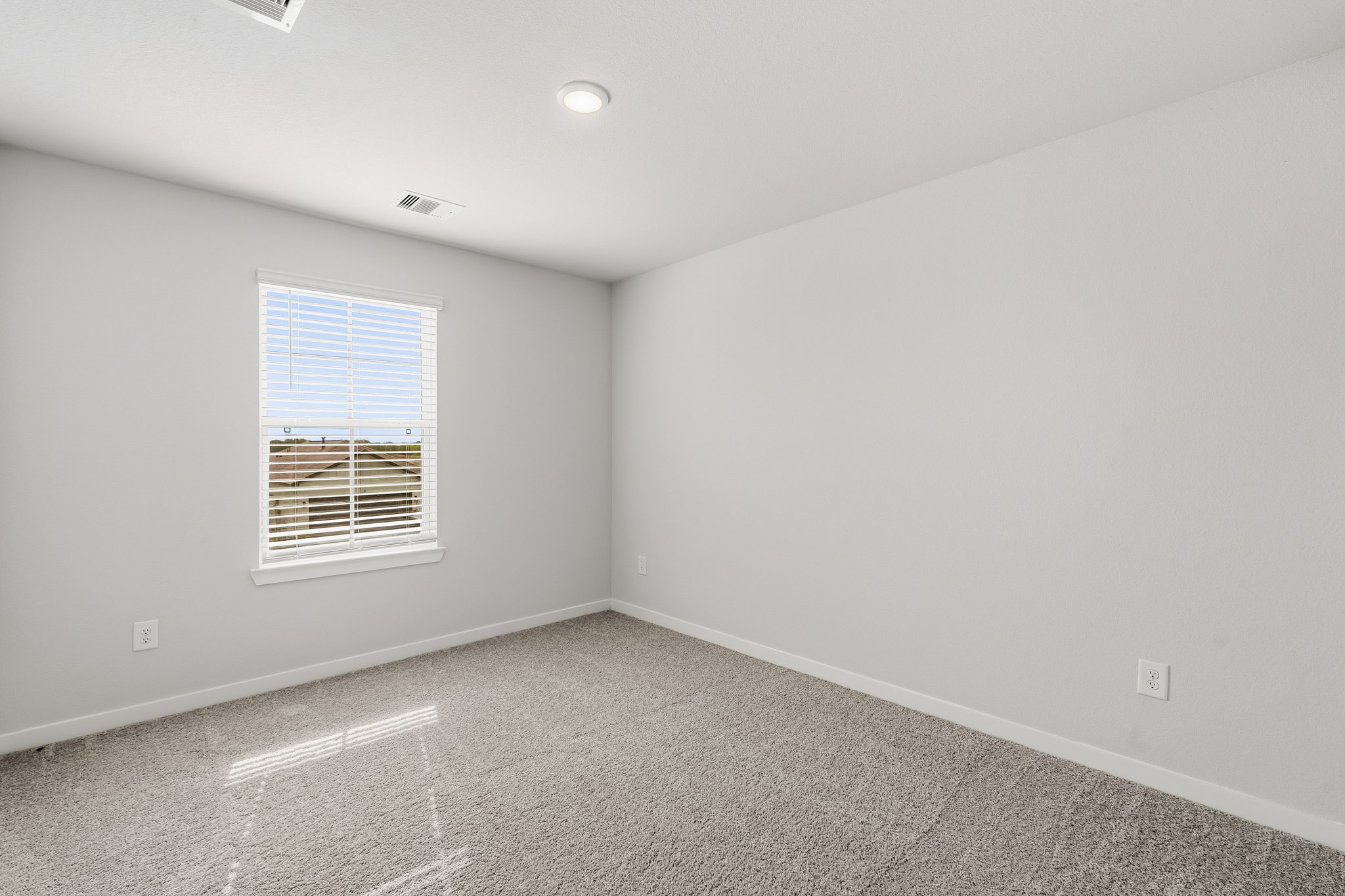 A room with a window and a carpet.
