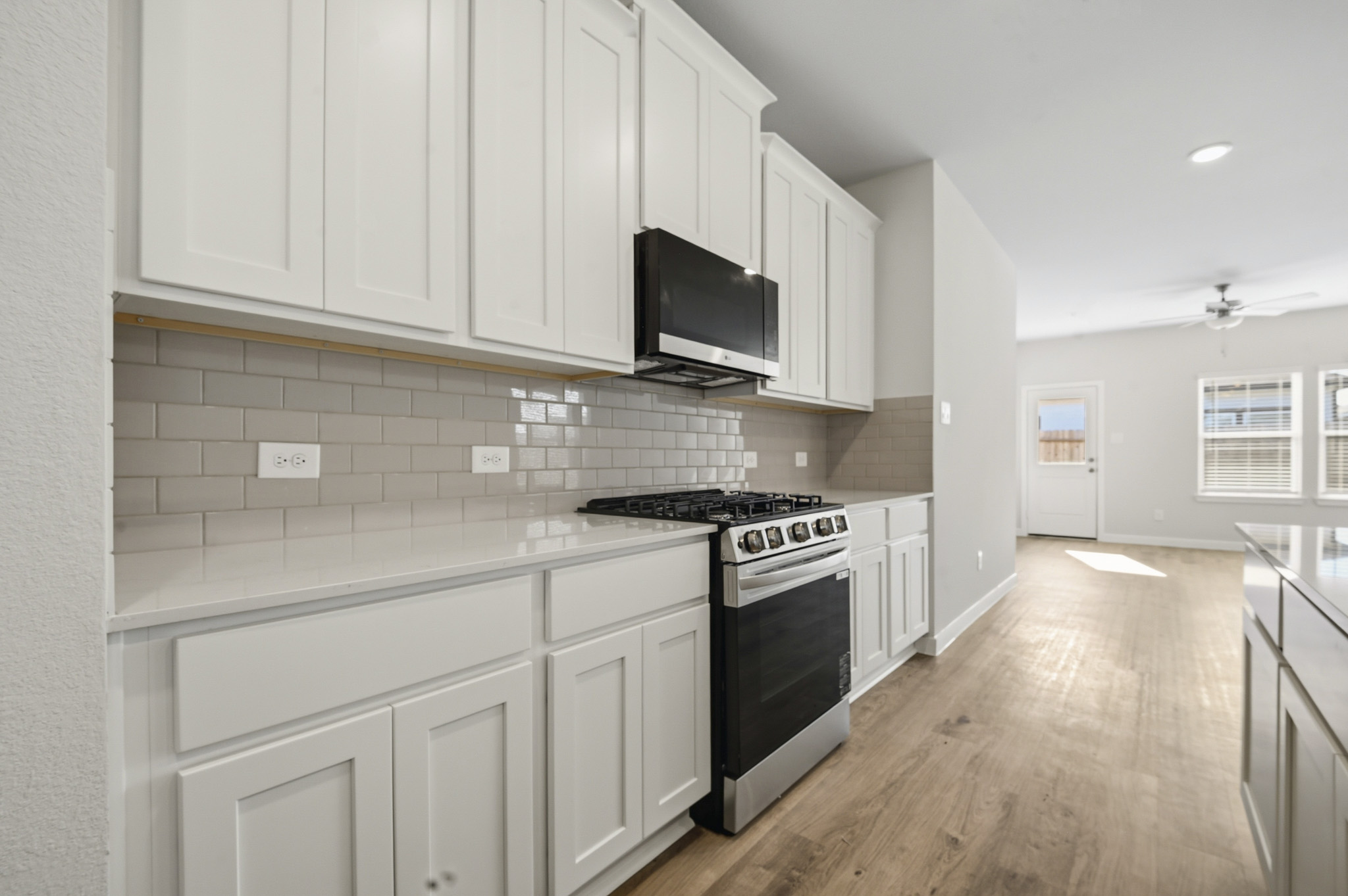 A kitchen with white cabinets.