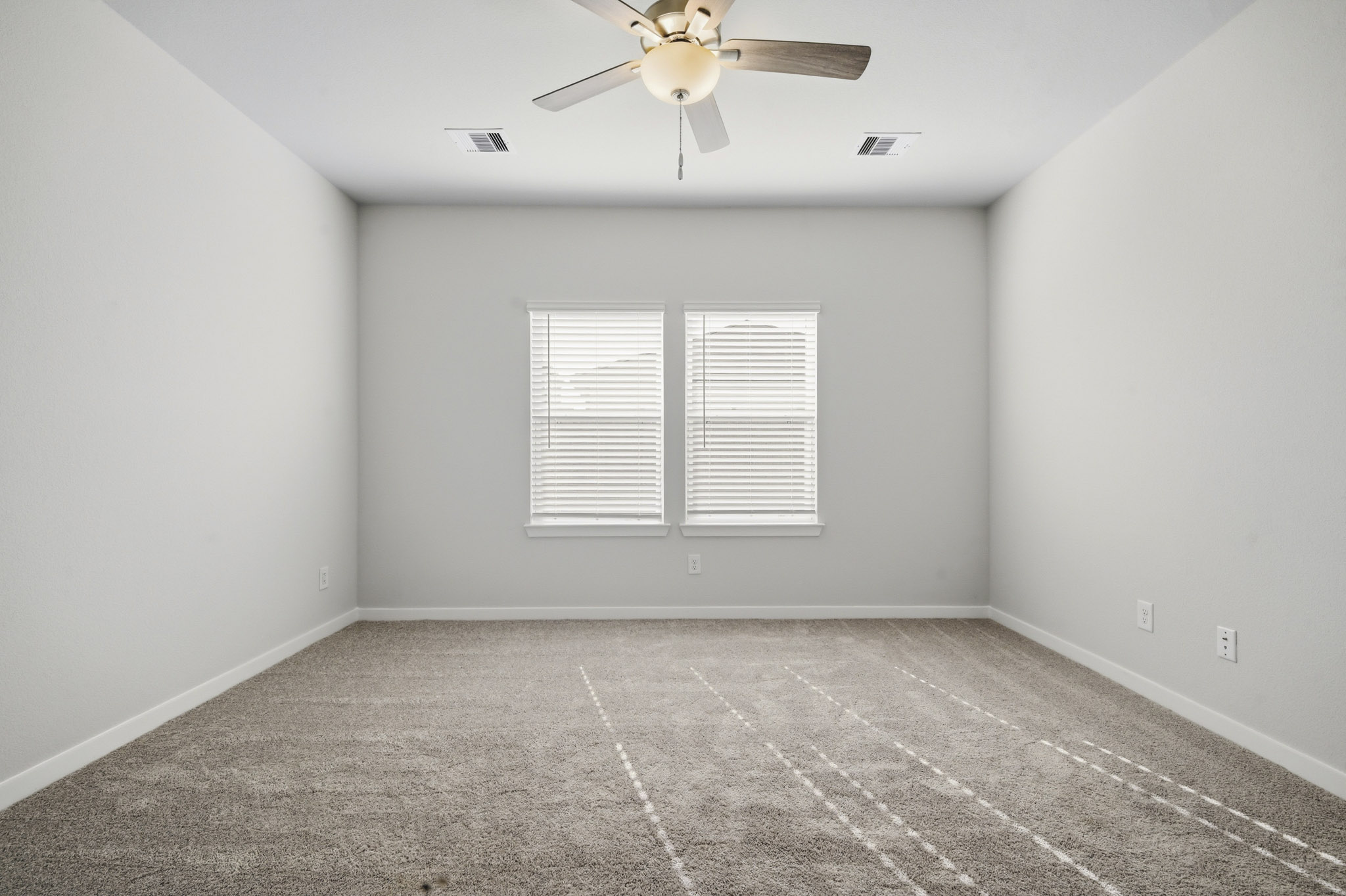 A room with a ceiling fan and a tile floor.