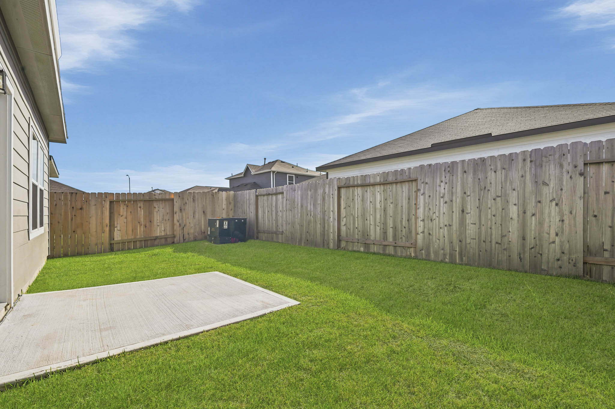 A fenced in yard with a house in the background.
