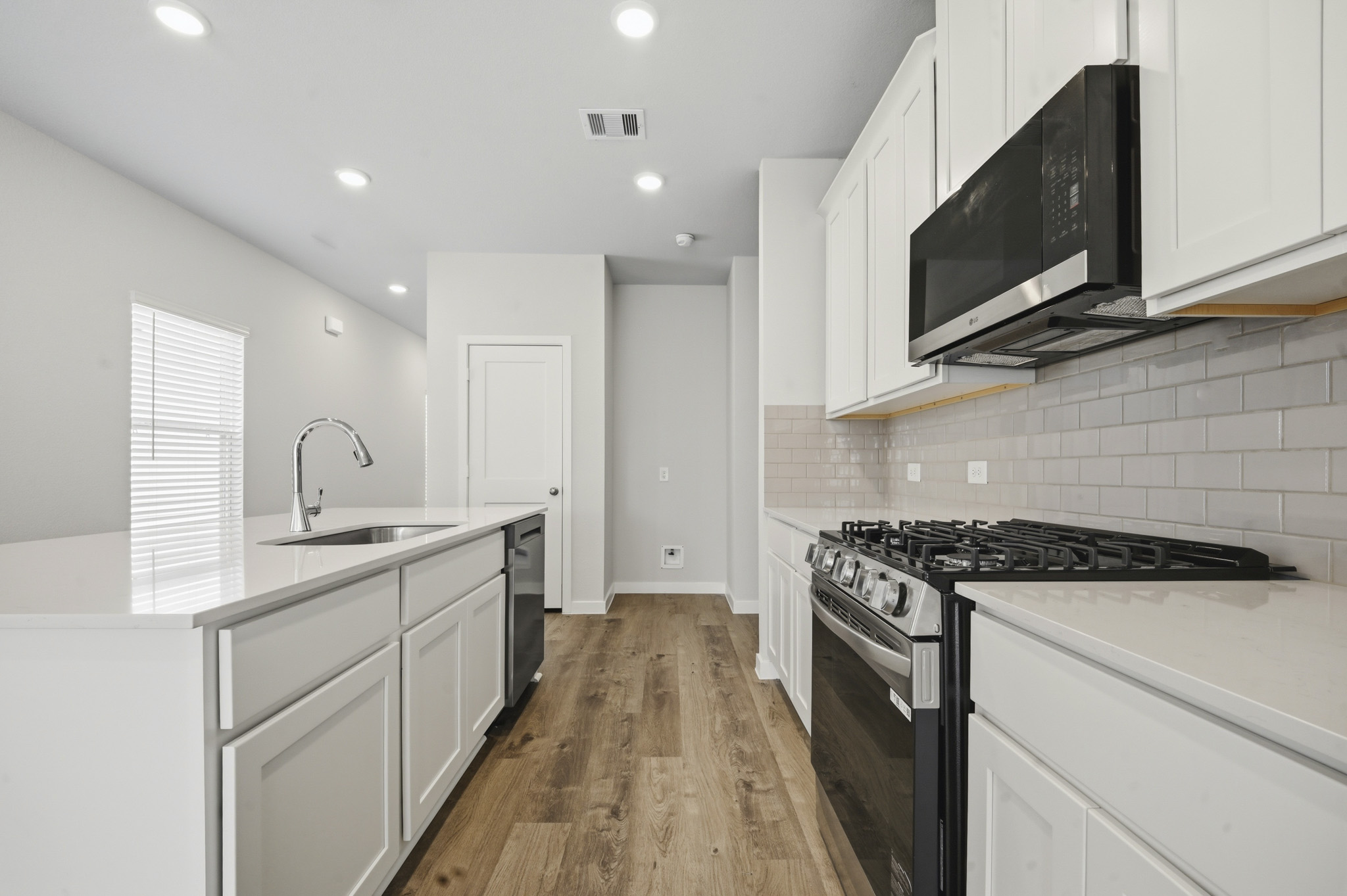 A kitchen with white cabinets.