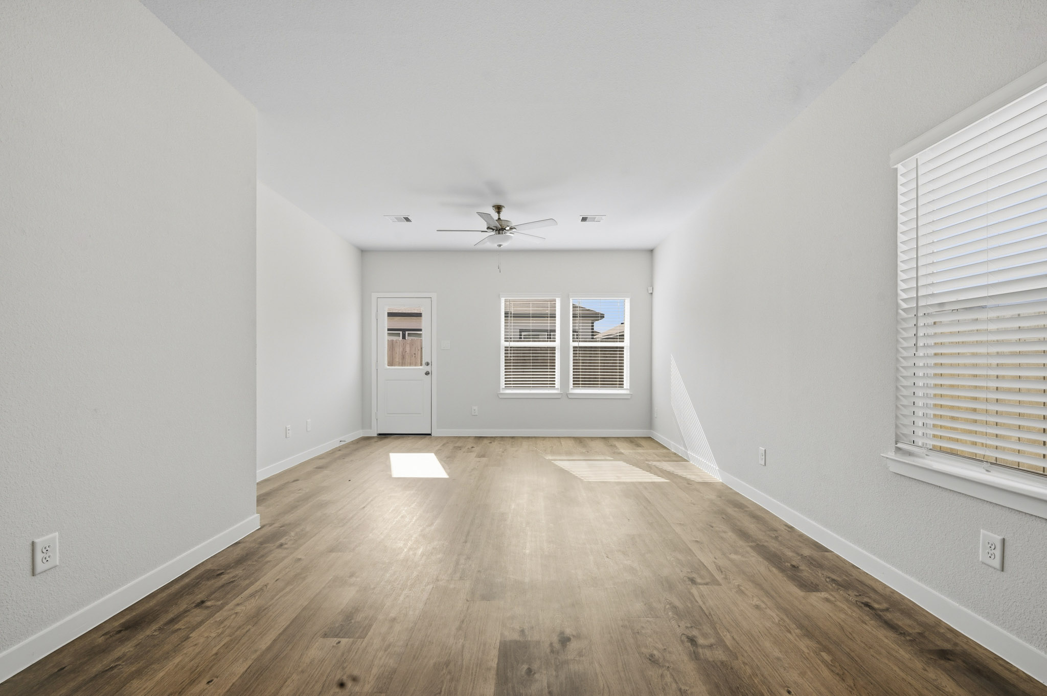 A room with a wood floor and a ceiling fan.