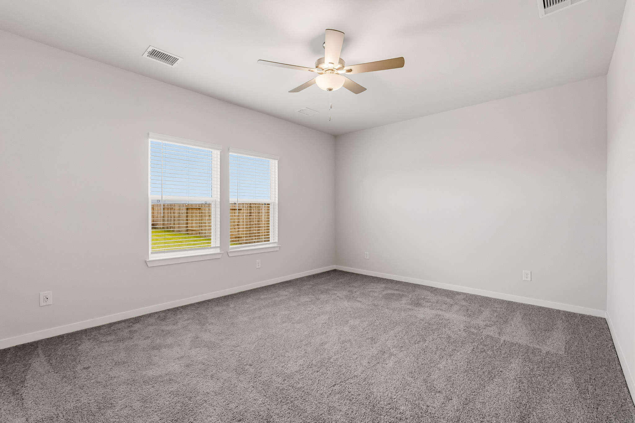 A room with a ceiling fan and a window.