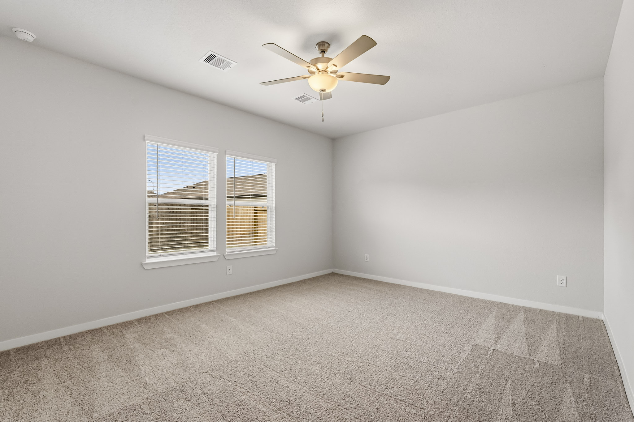 A room with a ceiling fan and a window.