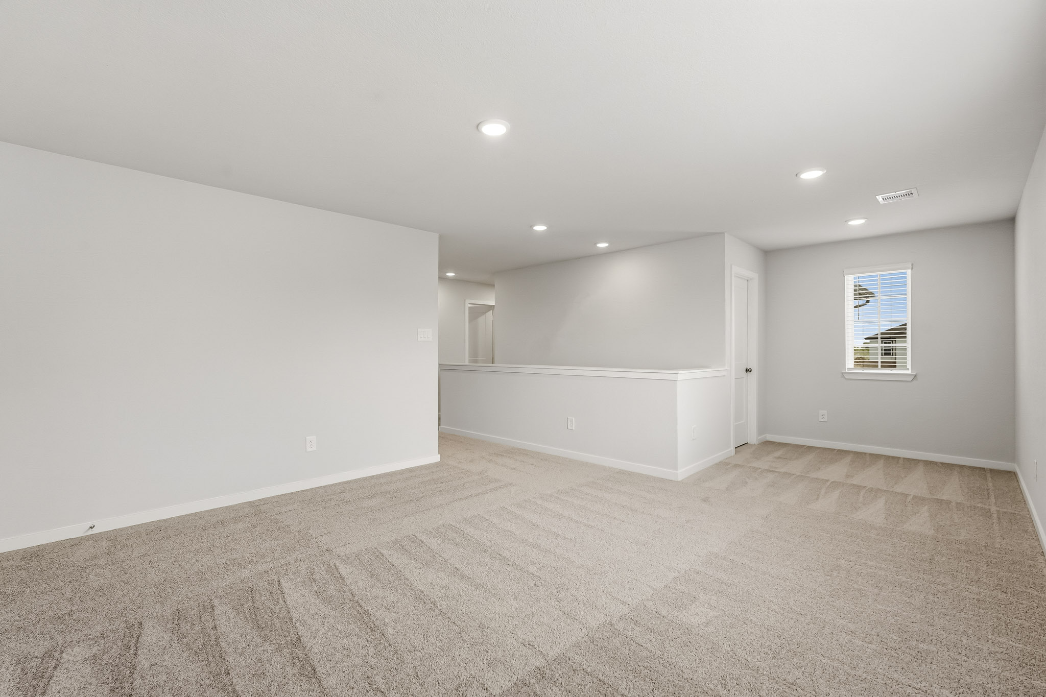 A room with a carpet and a window.
