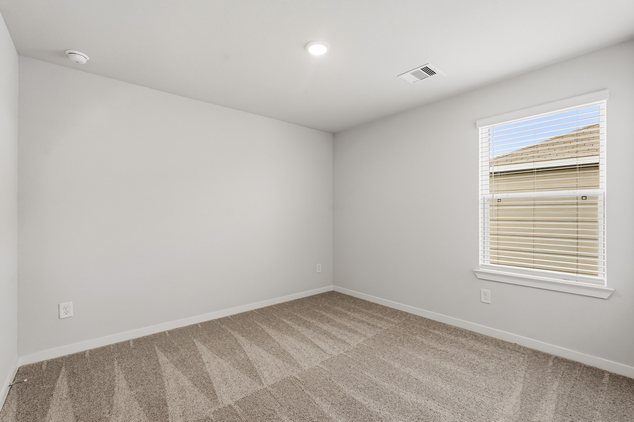 A room with a carpet and a window.