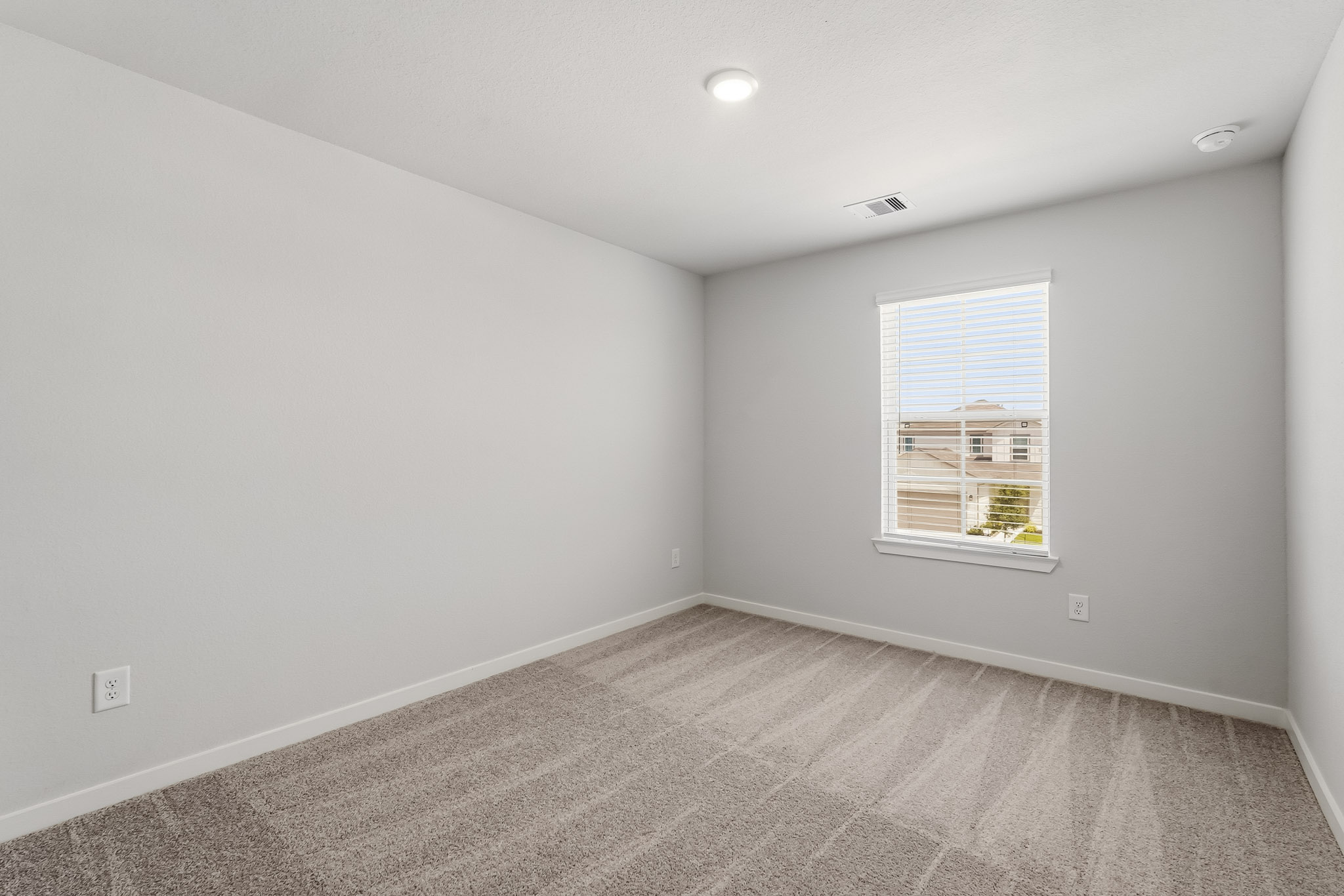 A room with a window and a carpet.