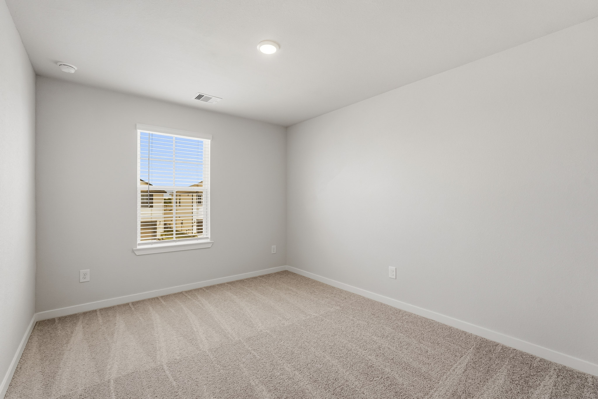 A room with a window and a carpet.