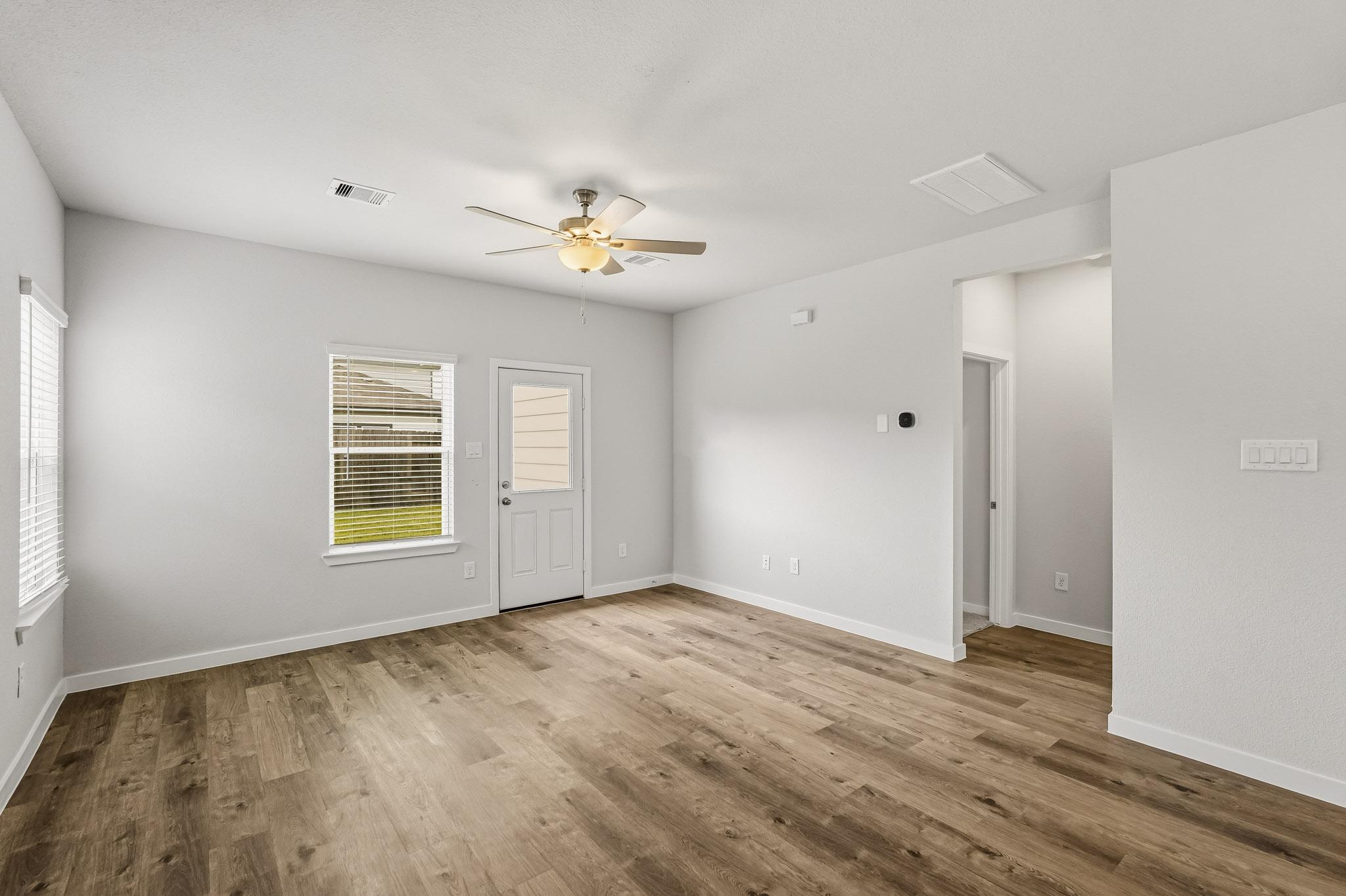 A room with a wood floor and a ceiling fan.