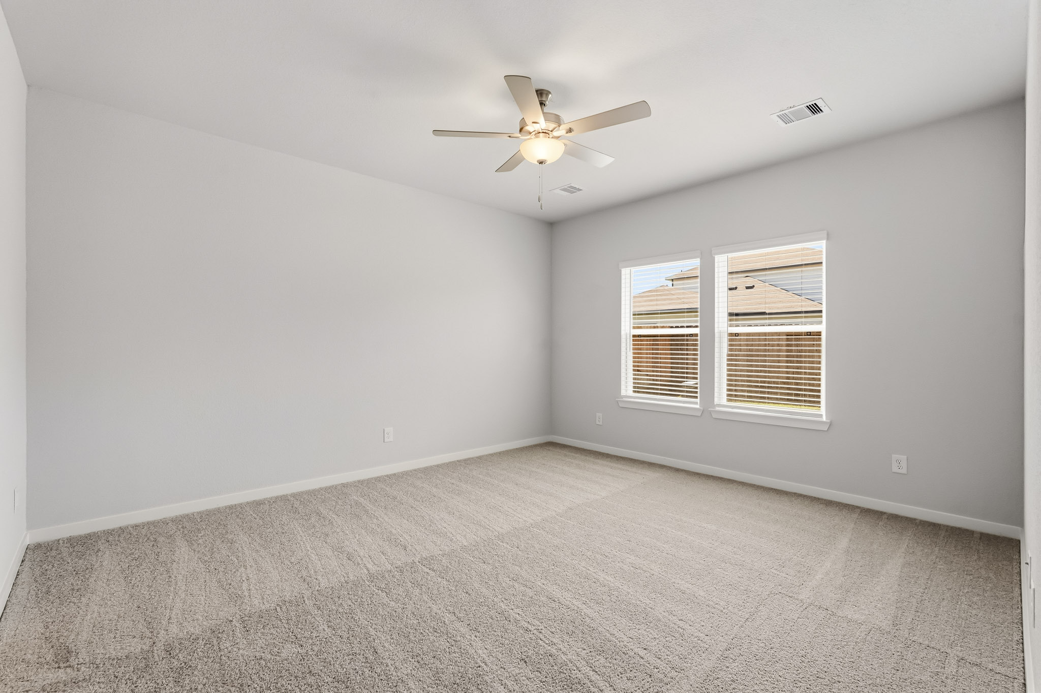 A room with a ceiling fan and a window.
