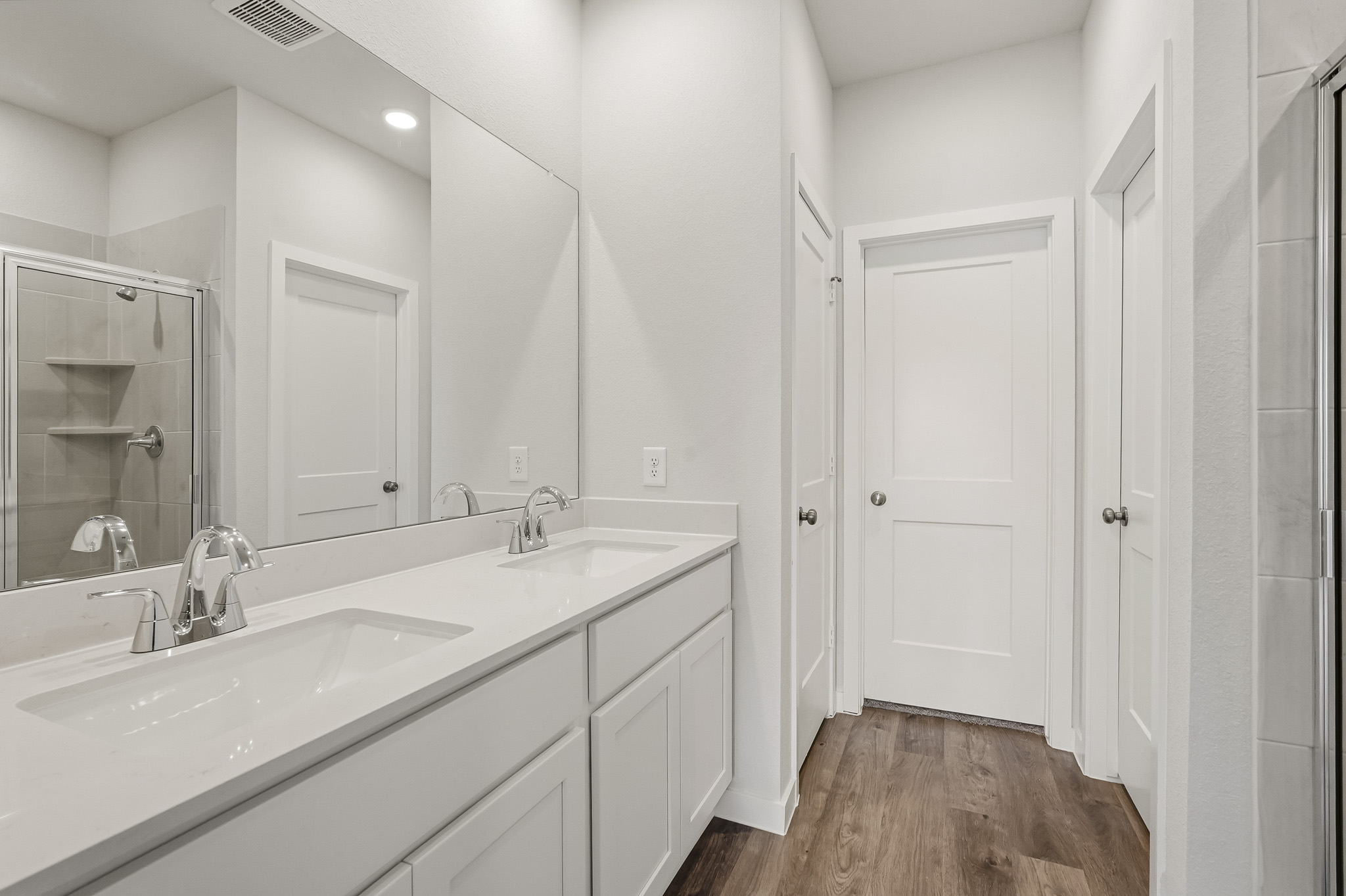 A bathroom with white cabinets.