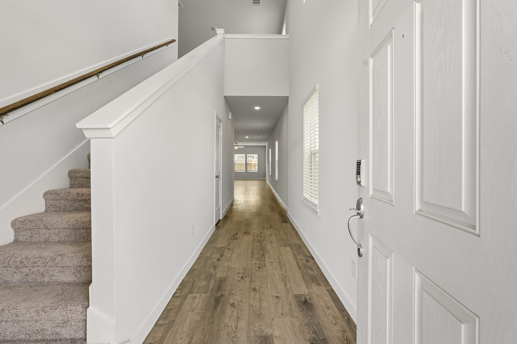 A long hallway with white doors.