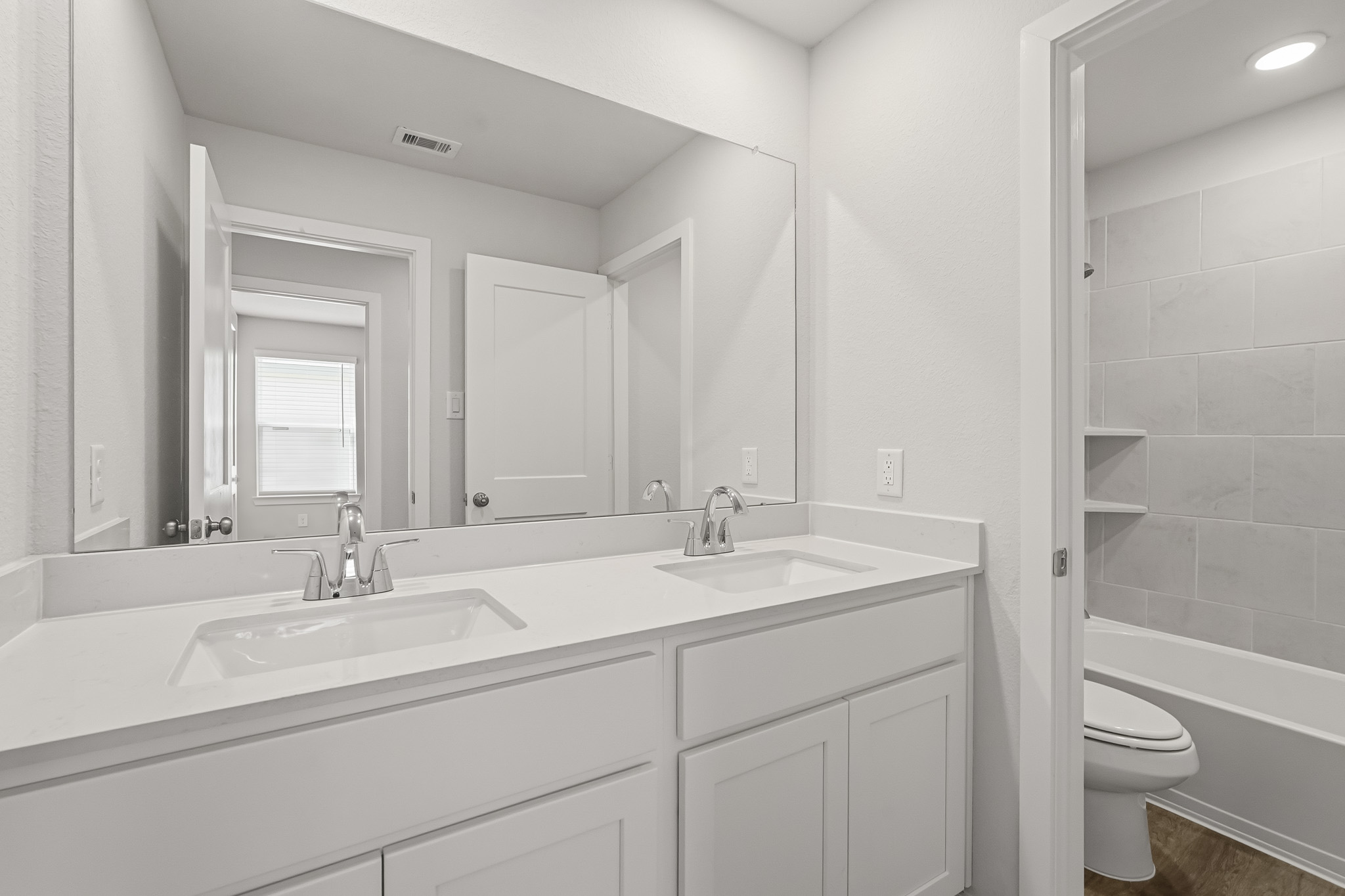 A bathroom with a sink toilet and mirror.