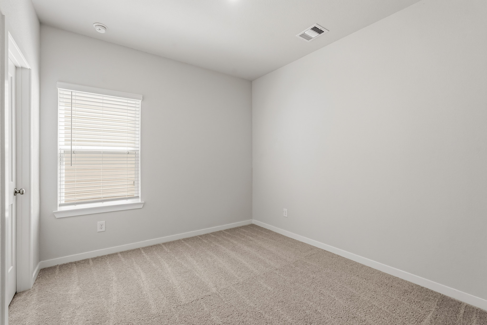 A room with a window and a carpet.
