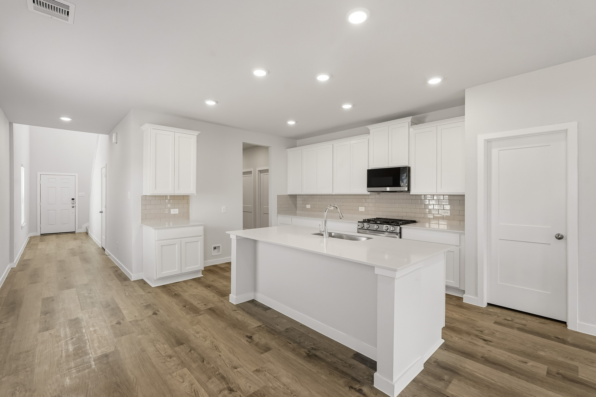 A kitchen with white cabinets.