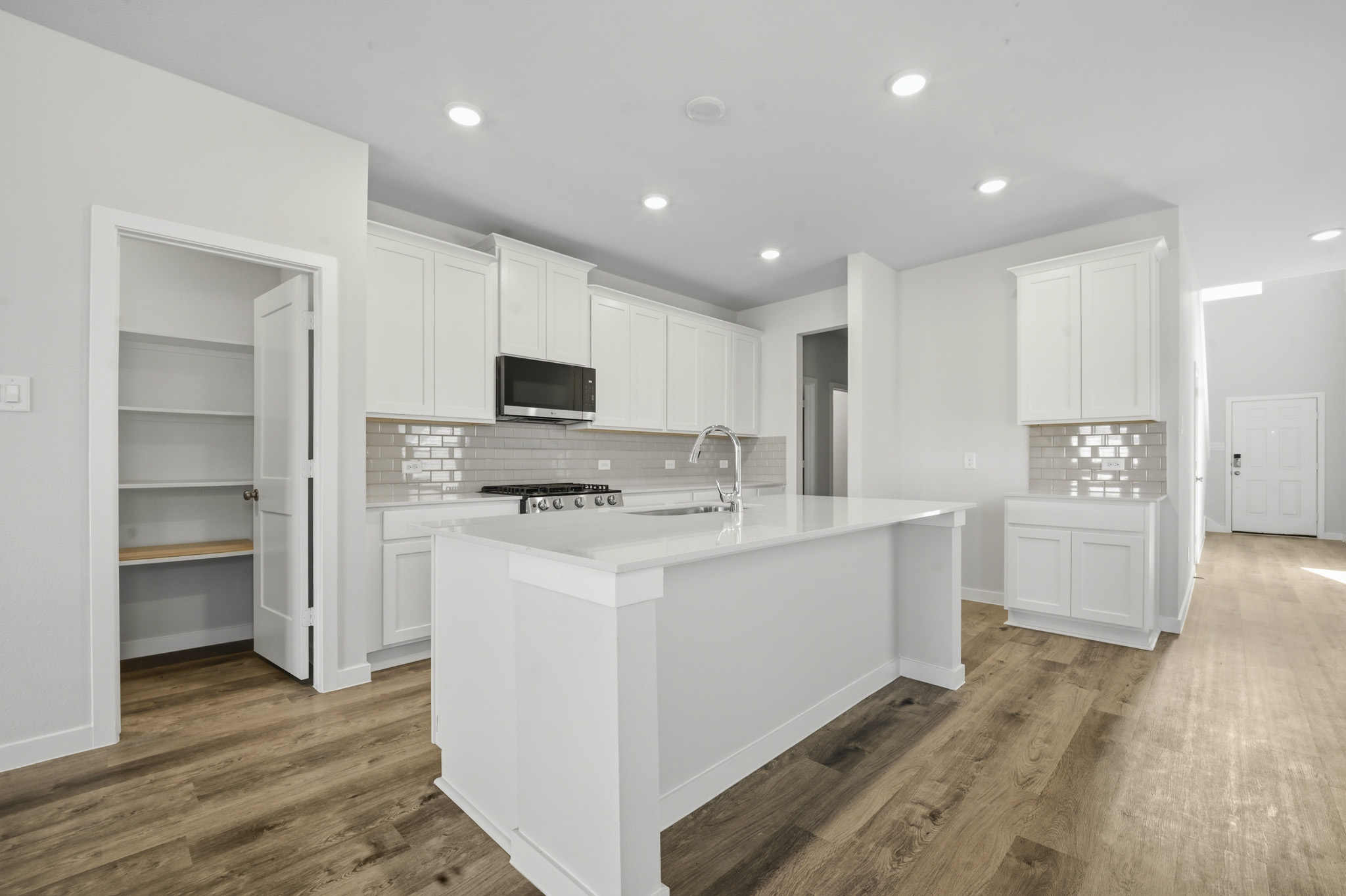 A kitchen with white cabinets.