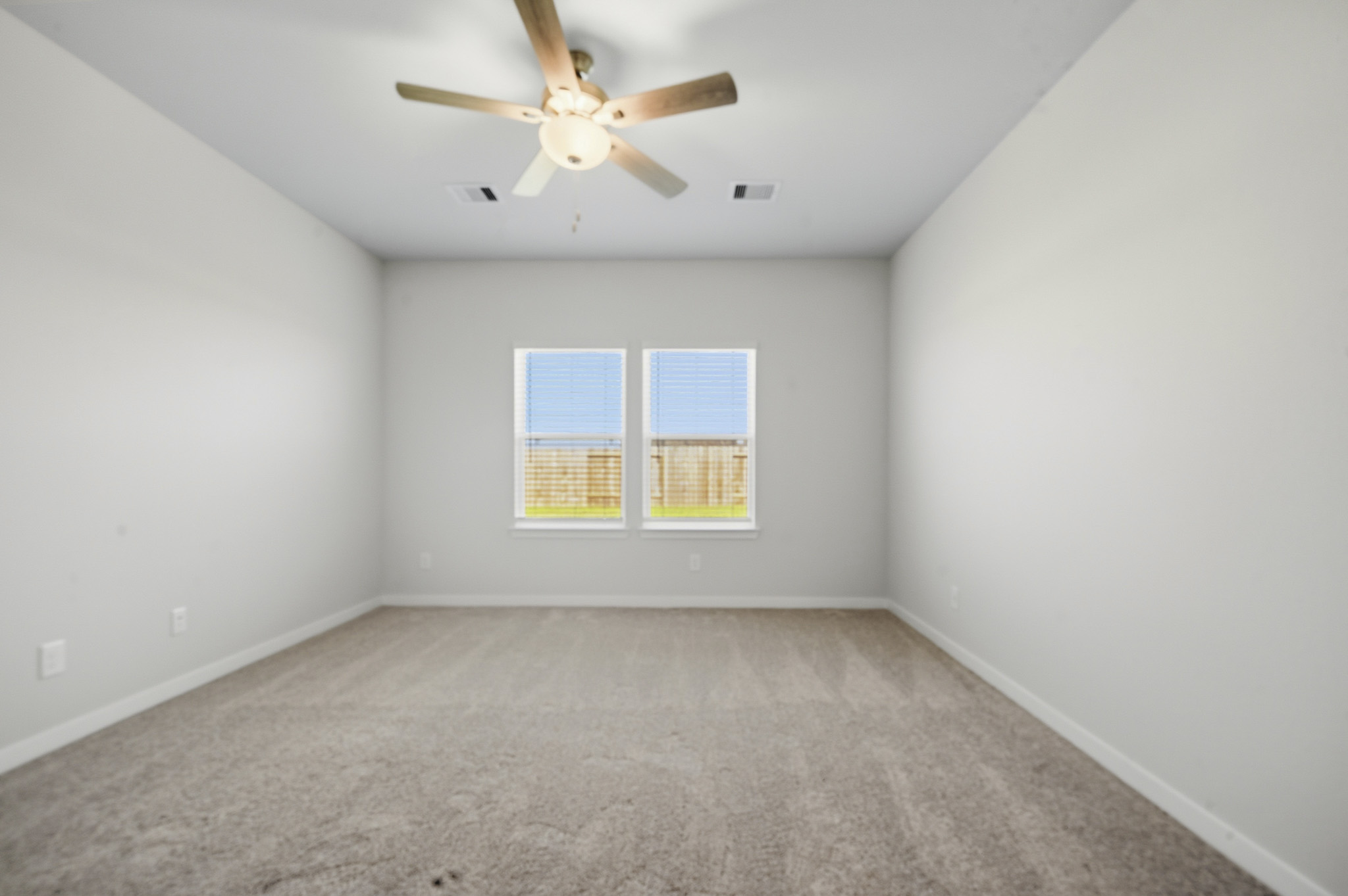 A room with a ceiling fan and a window.