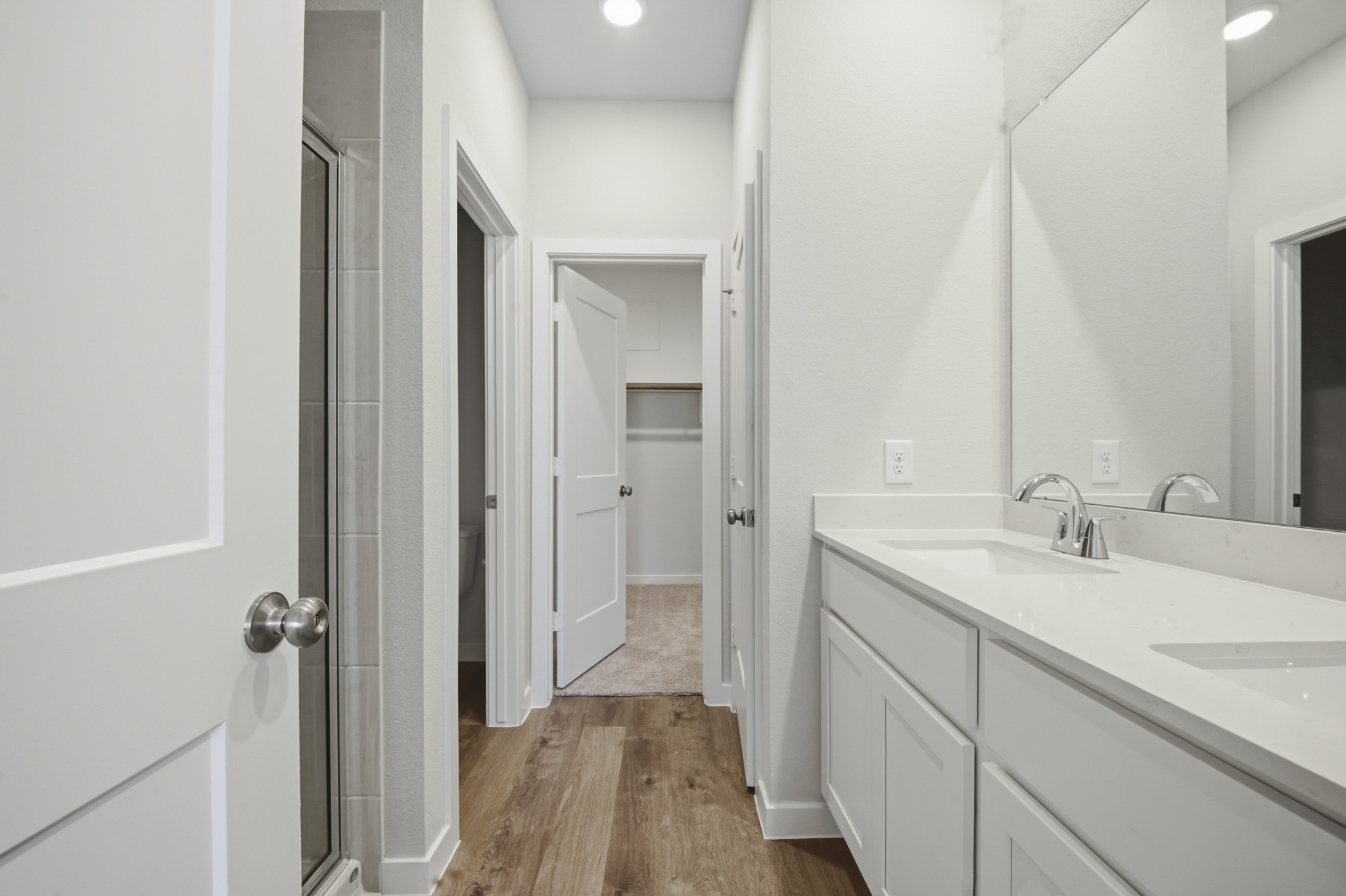 A bathroom with white cabinets.