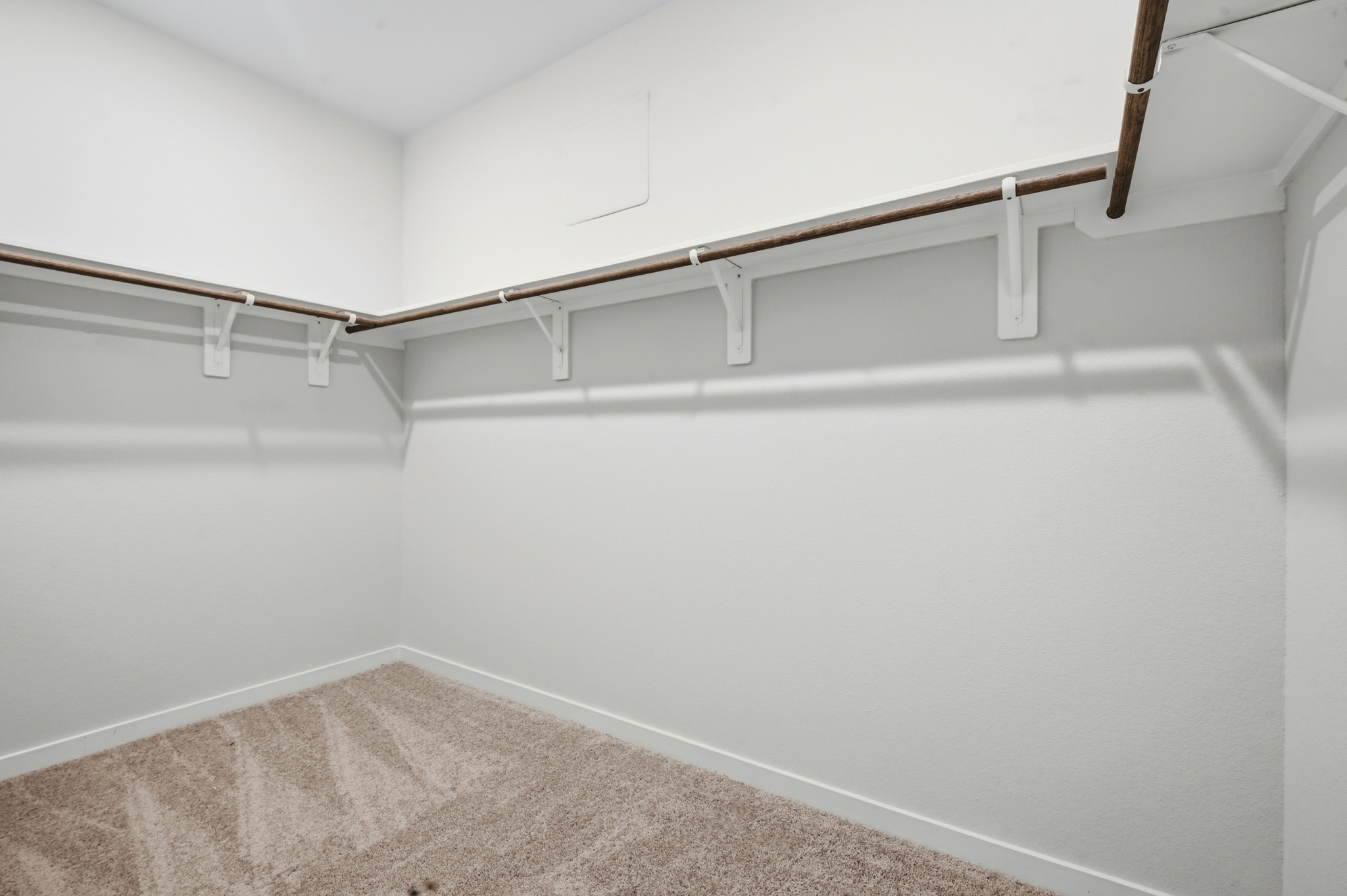 A white wall with a metal bar.