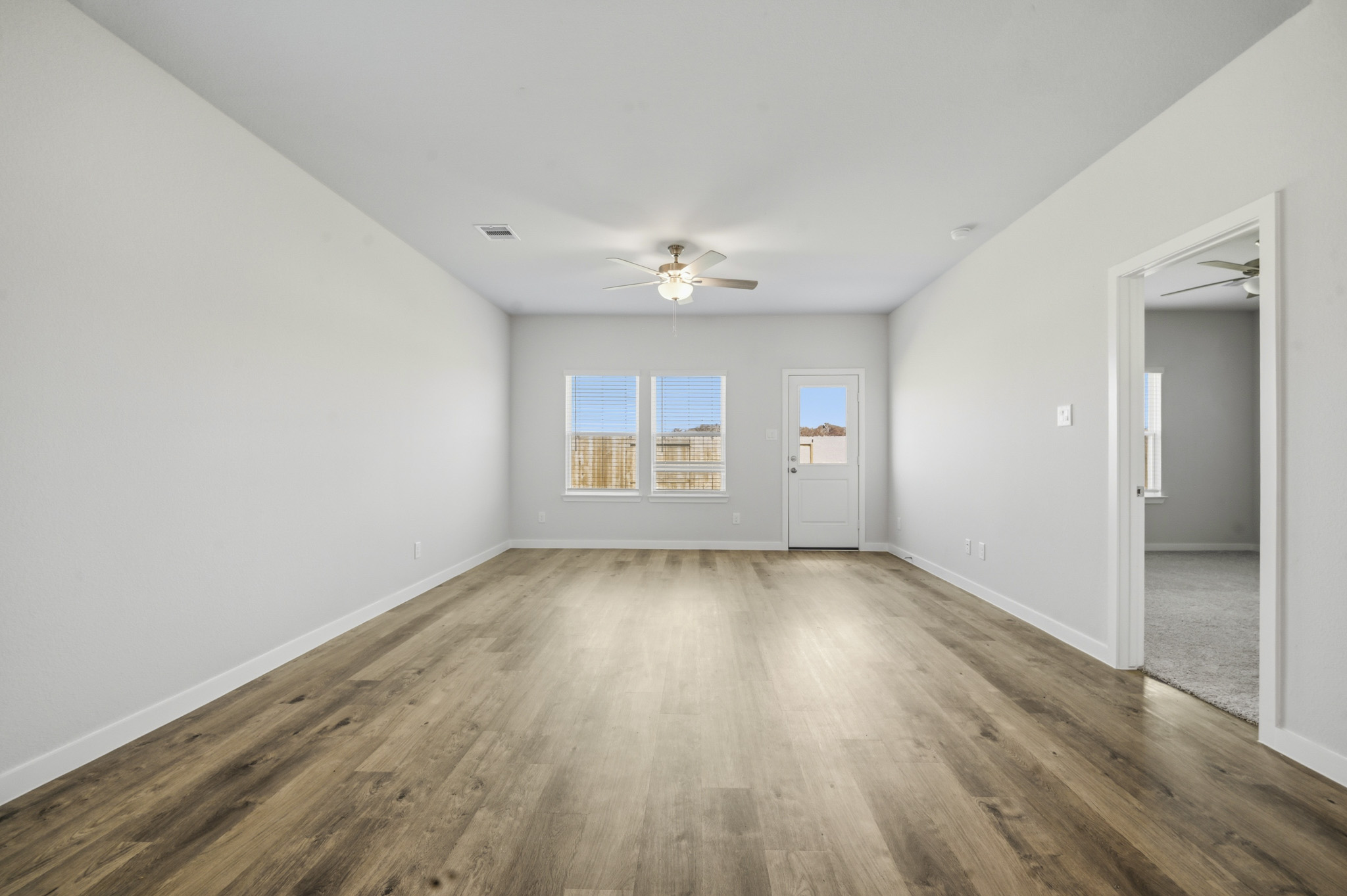 A room with a wood floor and a ceiling fan.