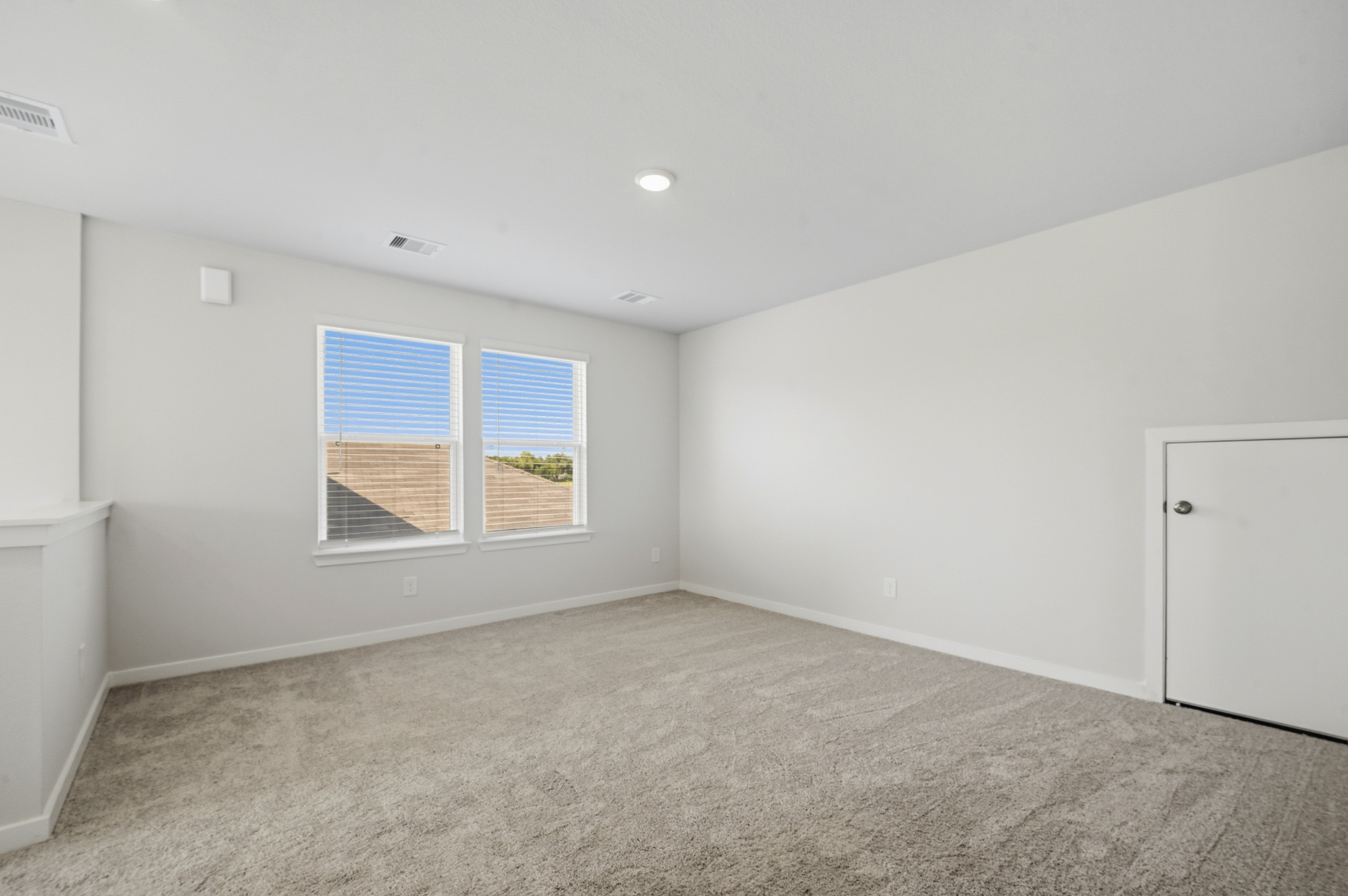 A room with a carpet and windows.