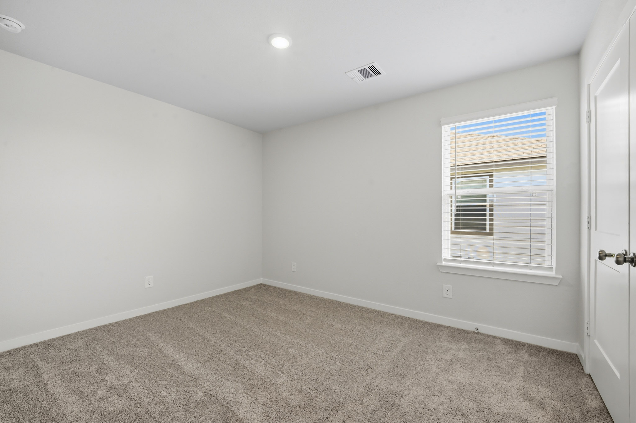 A room with a carpet and a window.