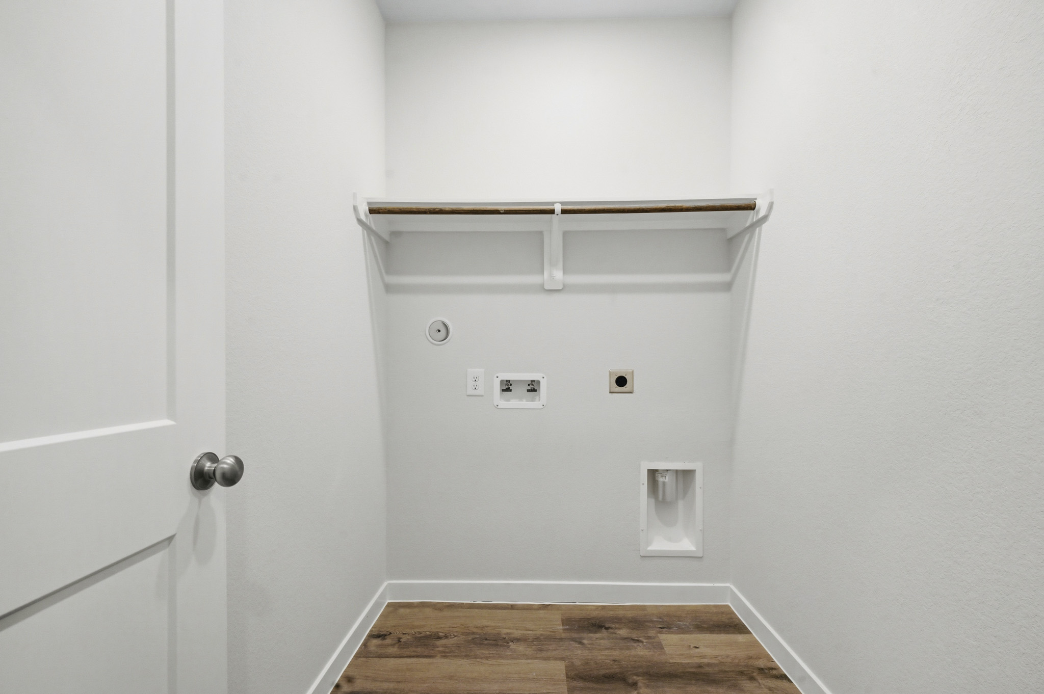 A white wall with a metal bar.