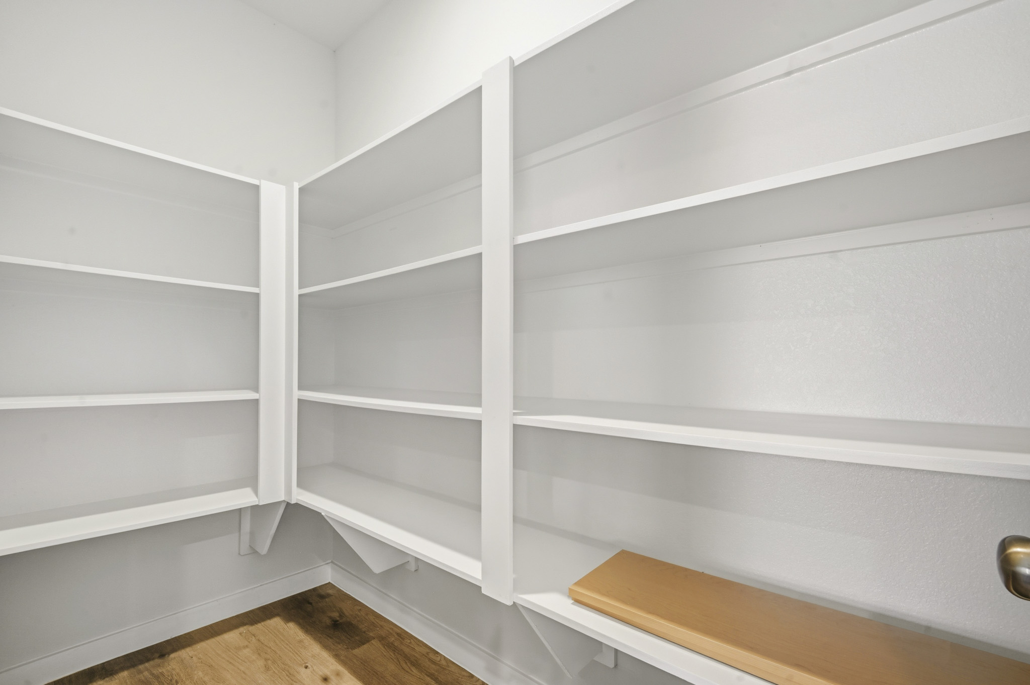 A white shelf with a wooden bench.